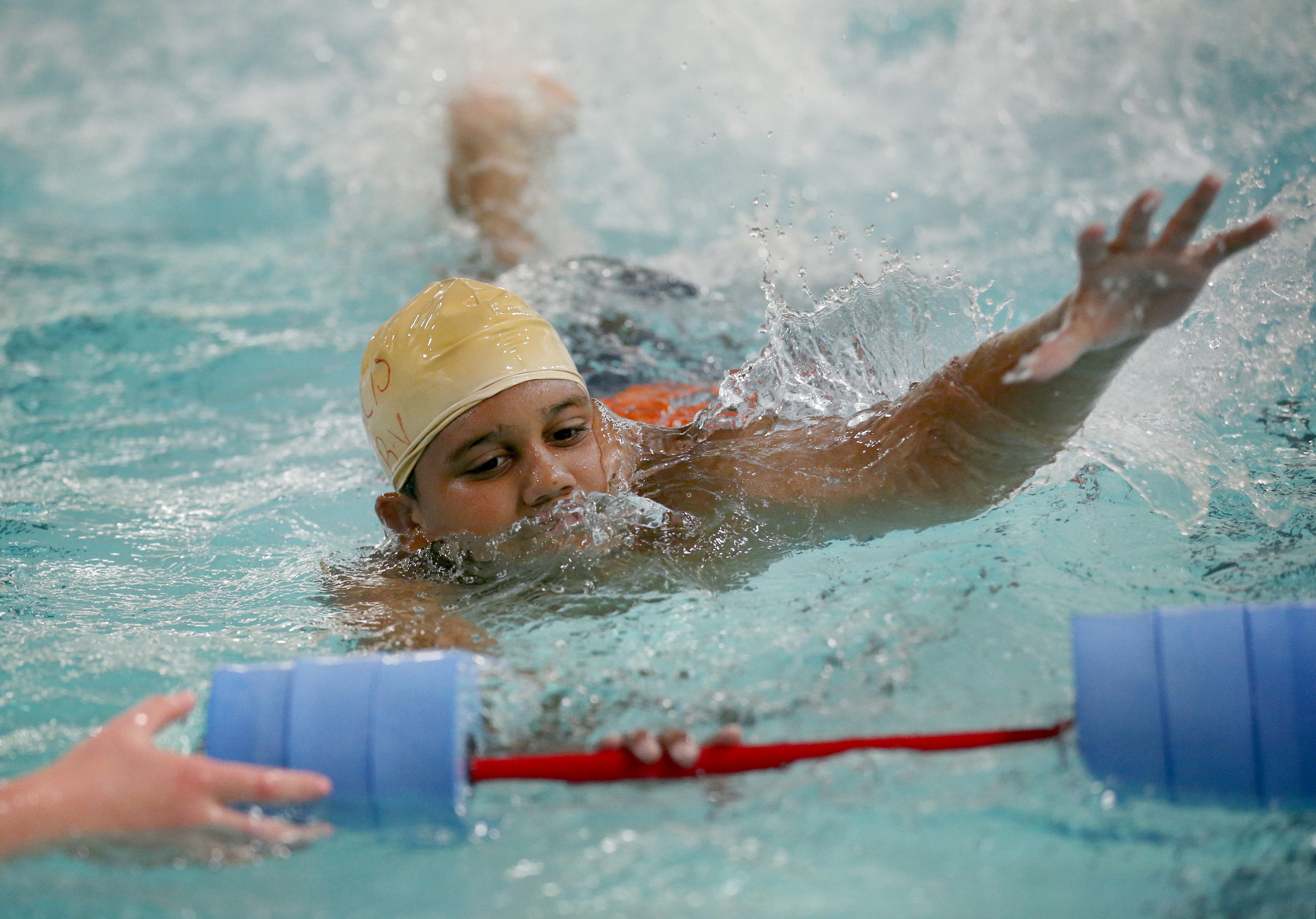 Ramcis Villar-Bueno, 12, swam with a bar float during a beginner’s swim class at the Lynn YMCA.