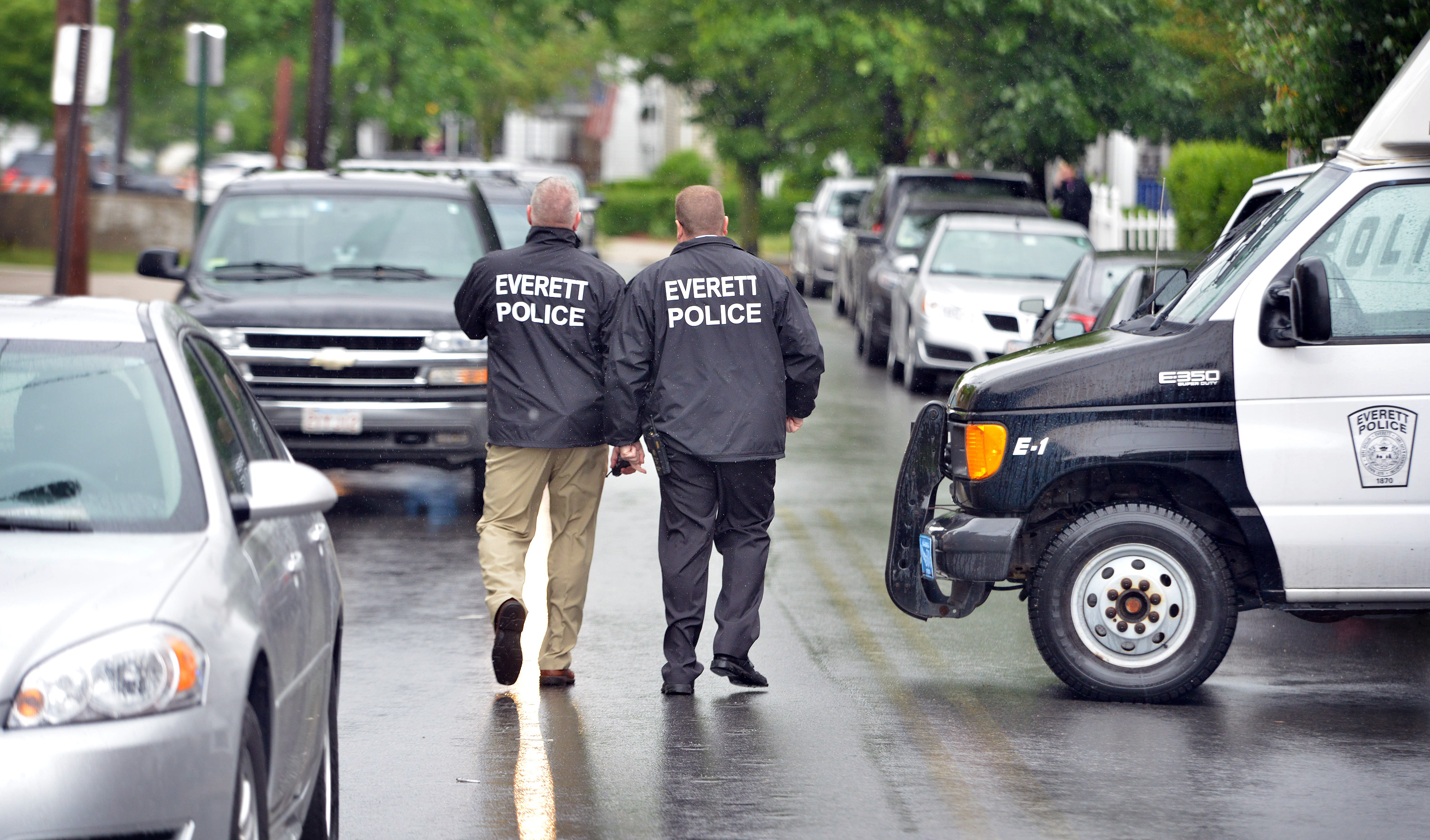 Everett police officers walked outside a house where FBI agents were investigating.