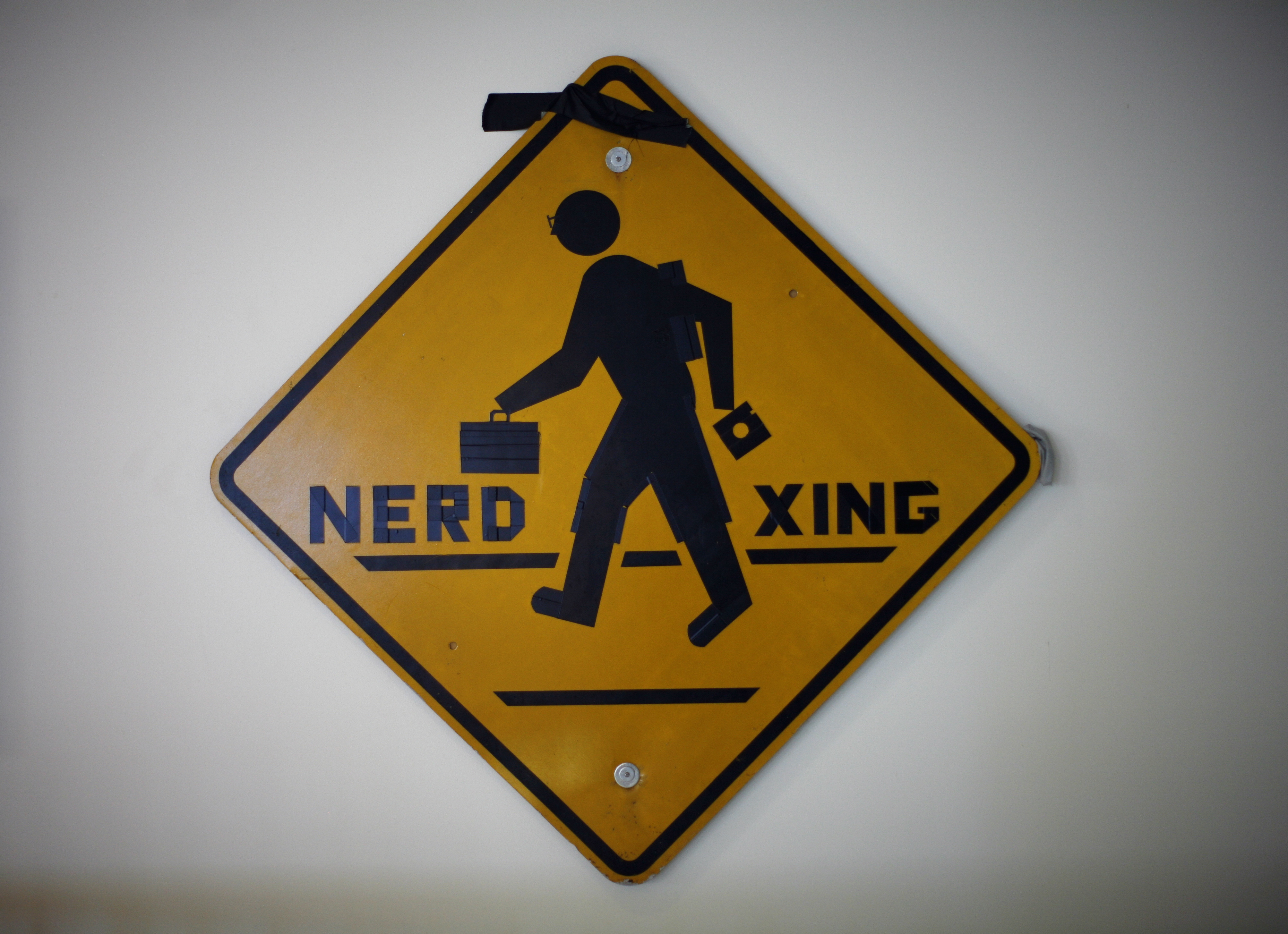 Some hacks bemoan the school’s culture while others celebrate it. This “Nerd Xing” sign, now on display in the Hall of Hacks, was put up on MIT’s campus in 1987.