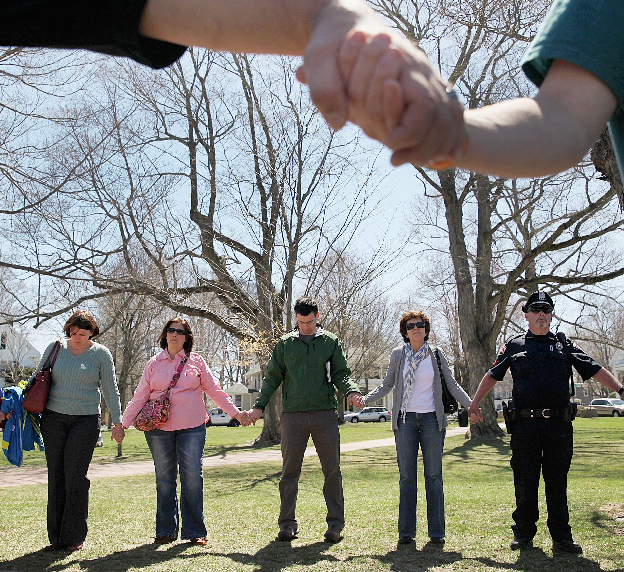 On Hopkinton’s town green, near the Marathon start, people joined hands to pray for those hurt and killed at the finish.