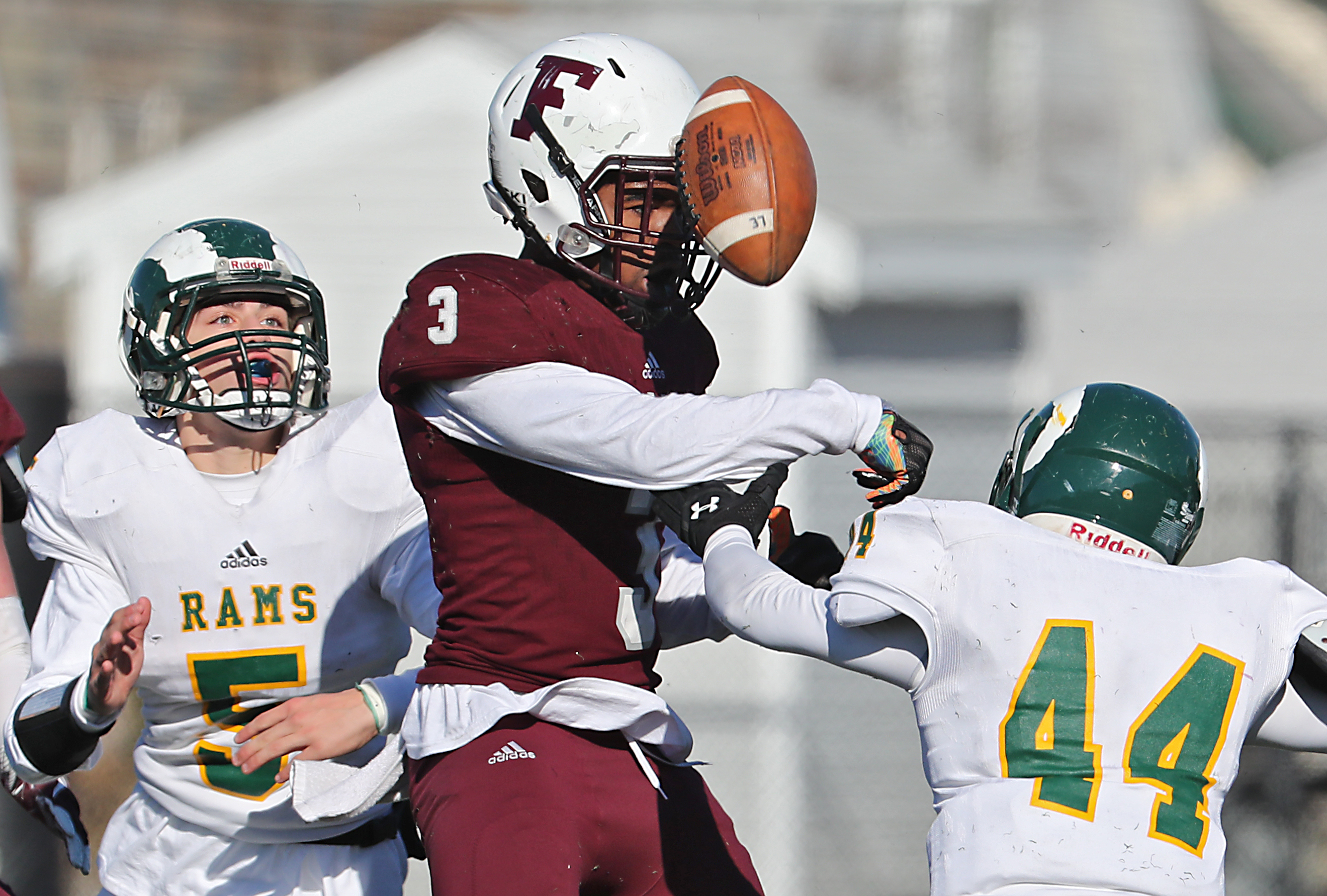 Ski Gaston of Lynn English knocked the ball loose from Lynn Classical’s Manny Guerrero (44) as Marcus Tucker looked on.