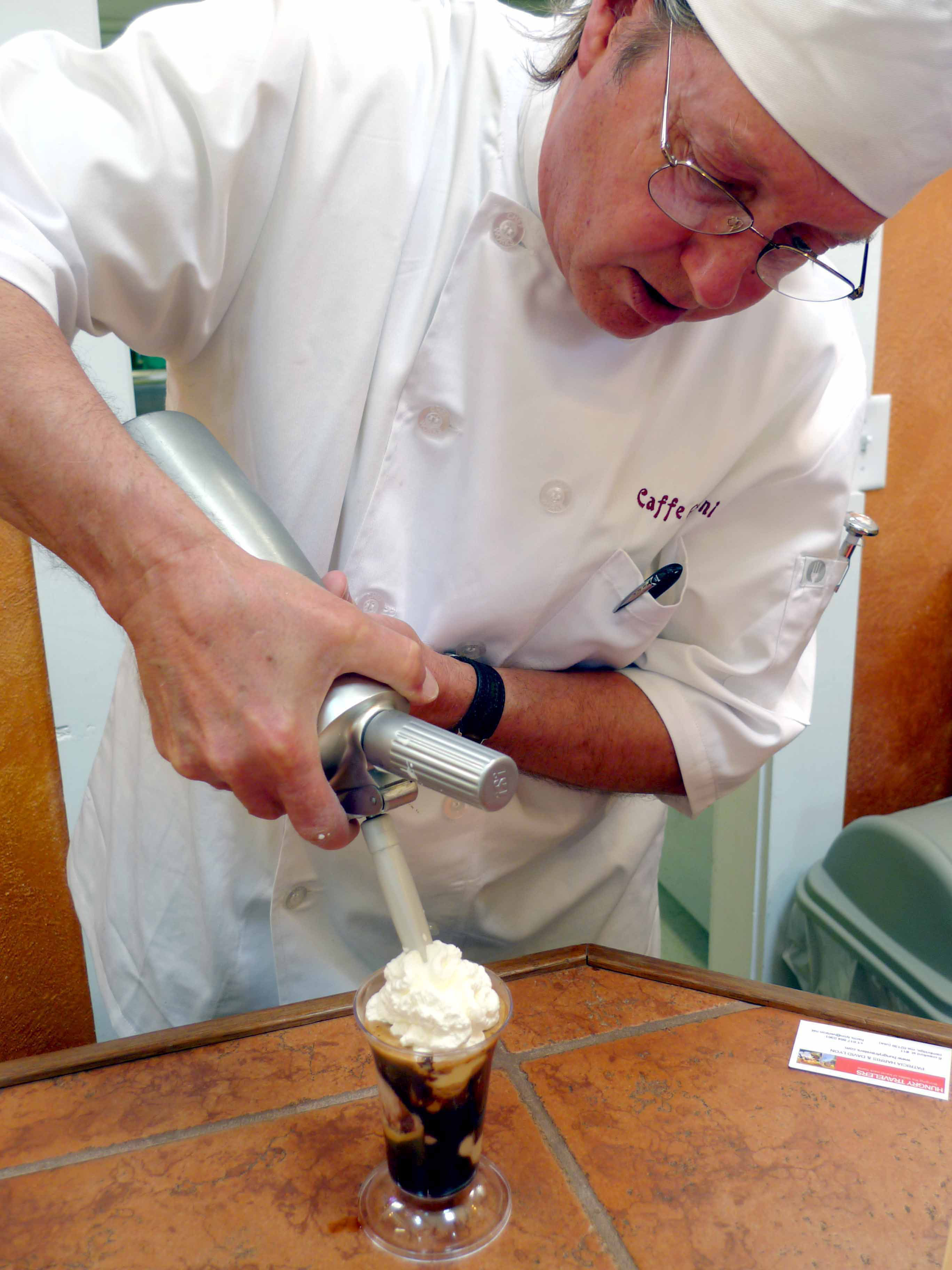 Tom Duby of Caffe Gelato Bertini puts the finishing touch of whipped cream on top of an affogato.