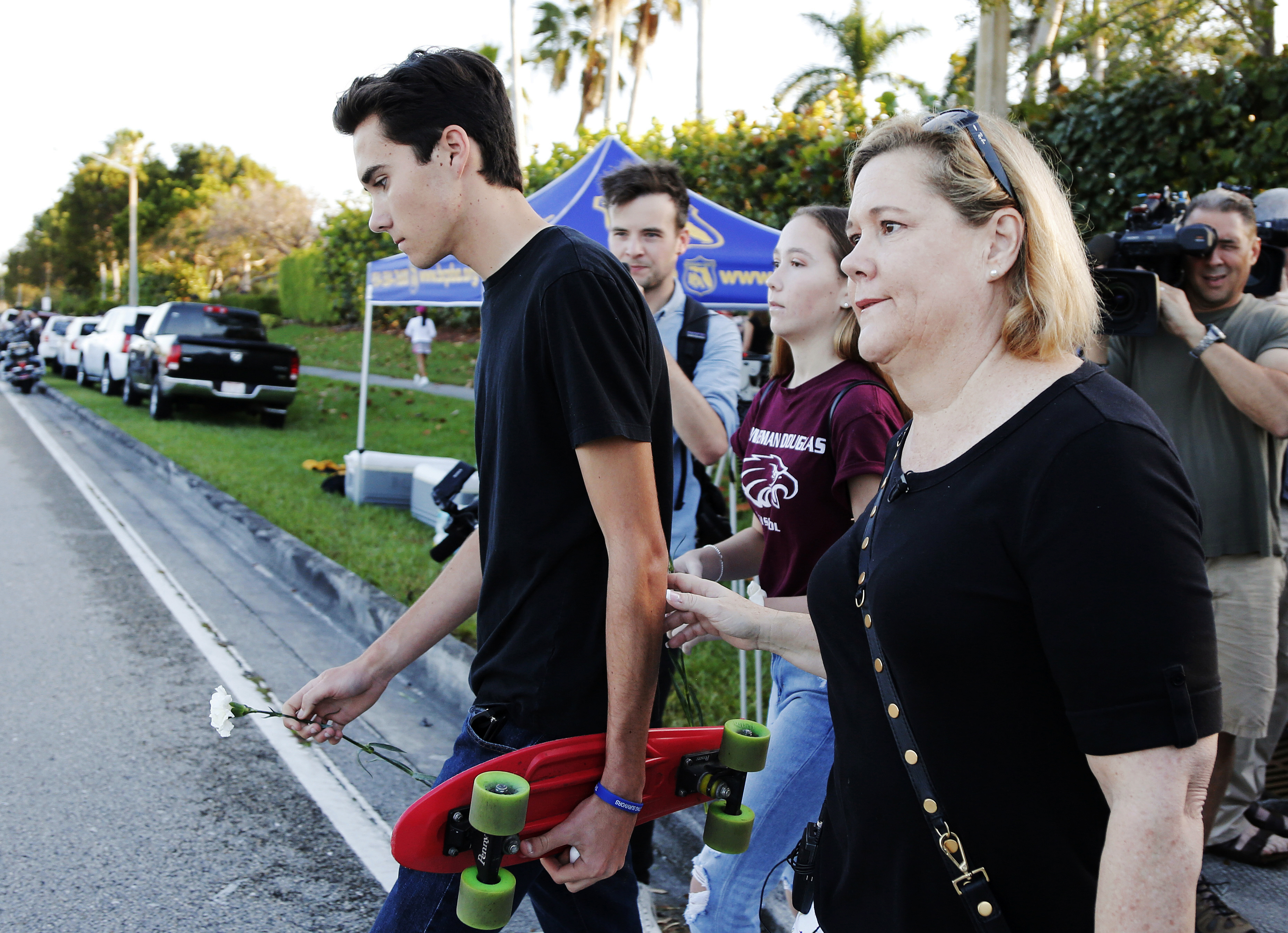 Marjory Stoneman Douglas High School student David Hogg, left, walked to class for the first time since a former student opened fire there with an assault weapon on Wednesday. "This is a picture of education in fear in this country. The NRA wants more people just like this, with that exact firearm to scare more people and sell more guns," said Hogg, who has become a leading voice in the students' movement to control assault weapons.