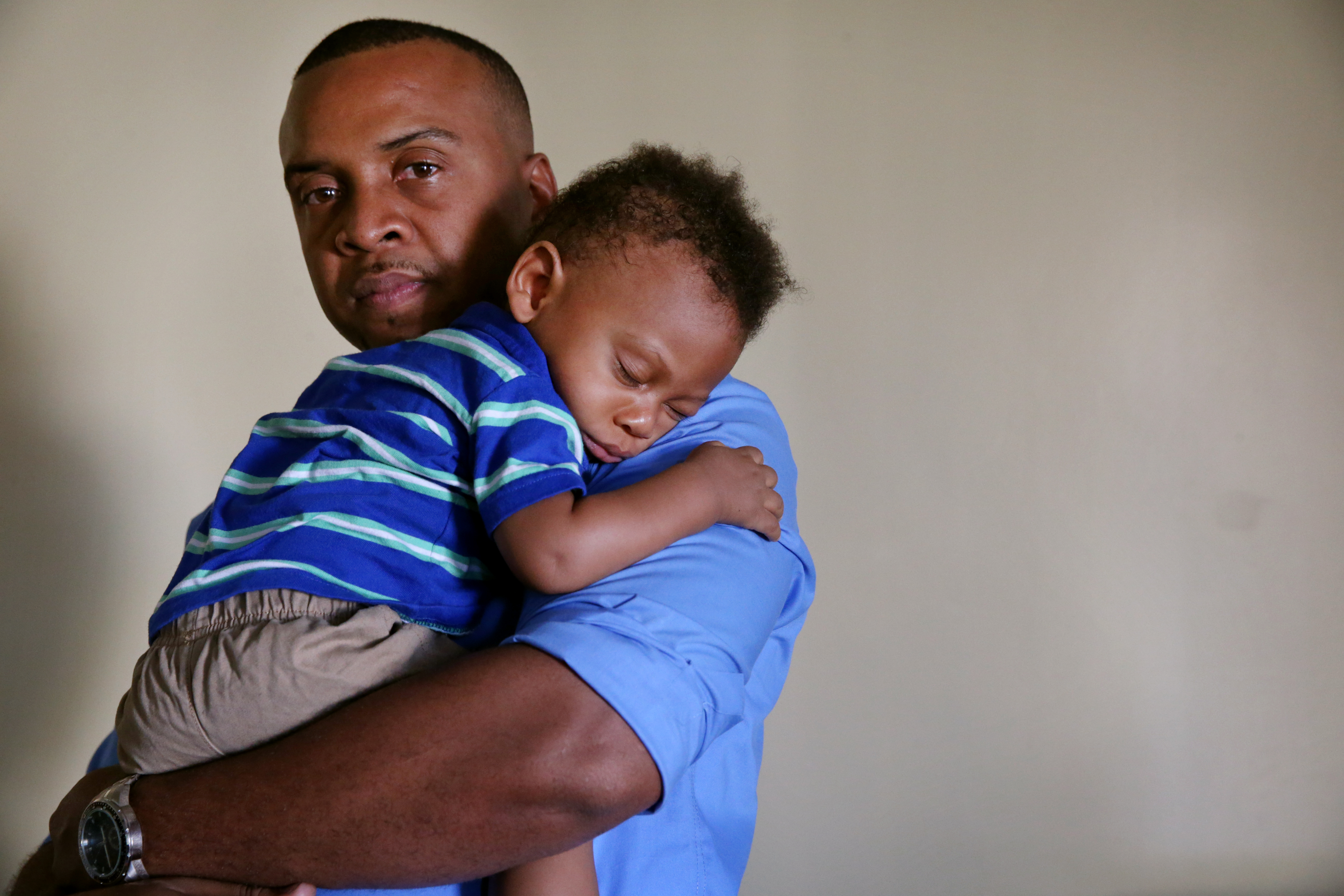 Kenny Fuchu posed for a portrait with his sleeping son, Kenneth, who is 8-months-old.