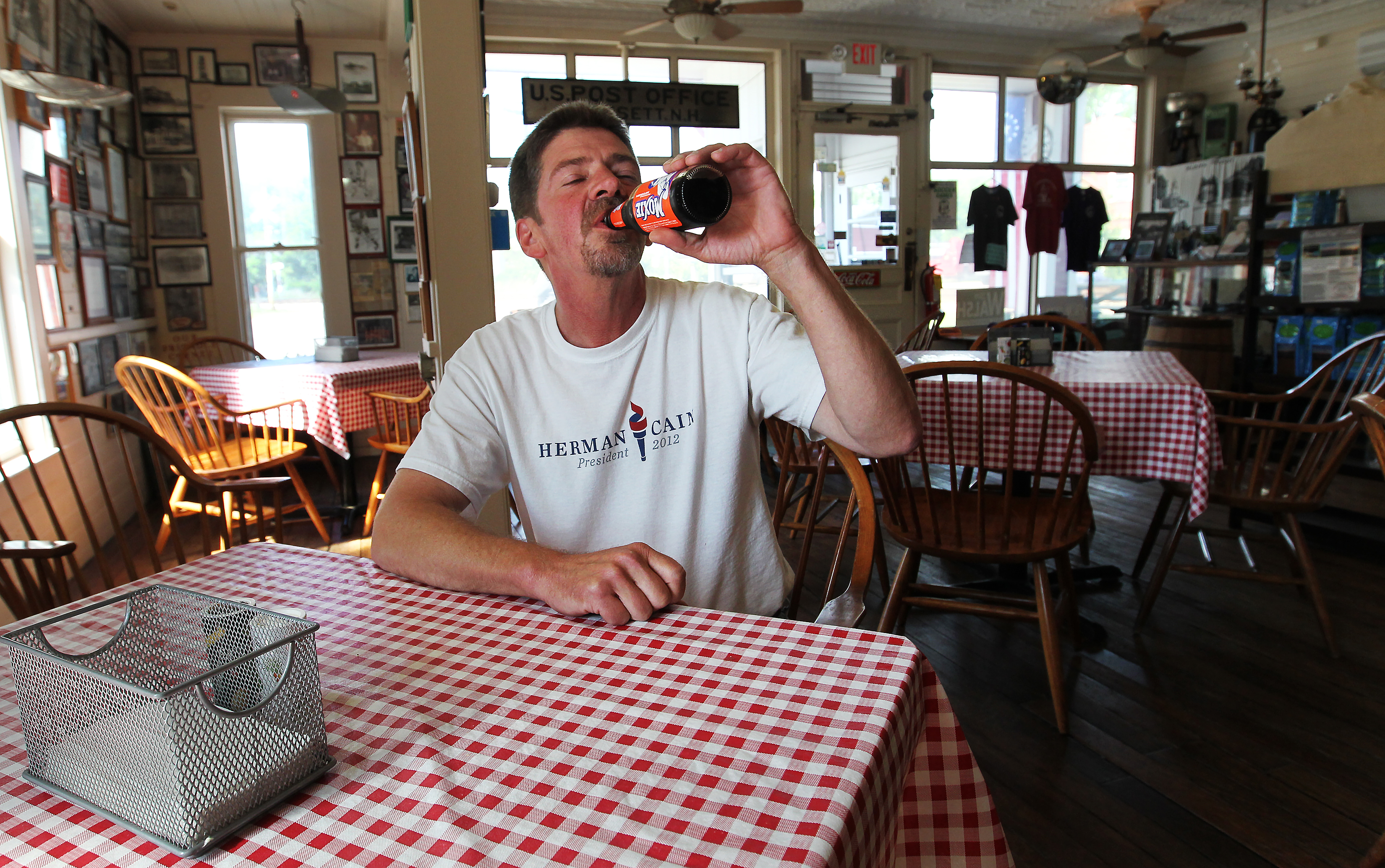 Walsh drank a bottle of Moxie while sitting at one of his tables.
