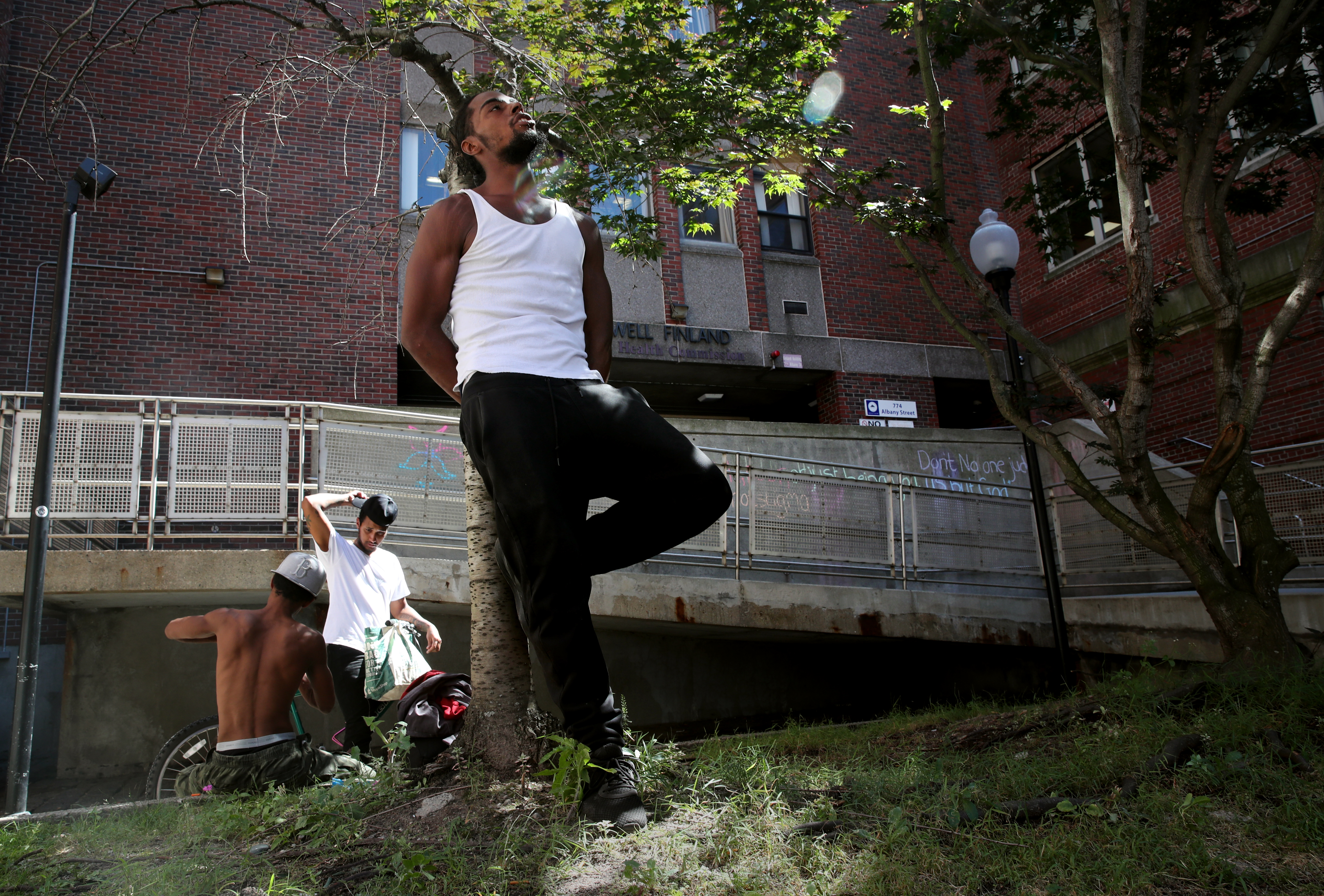 Malik Calderon Jr. leaned against a tree outside the Boston Public Health Commission on Albany Street. Malik said he is homeless and relies on friends and family to get by.