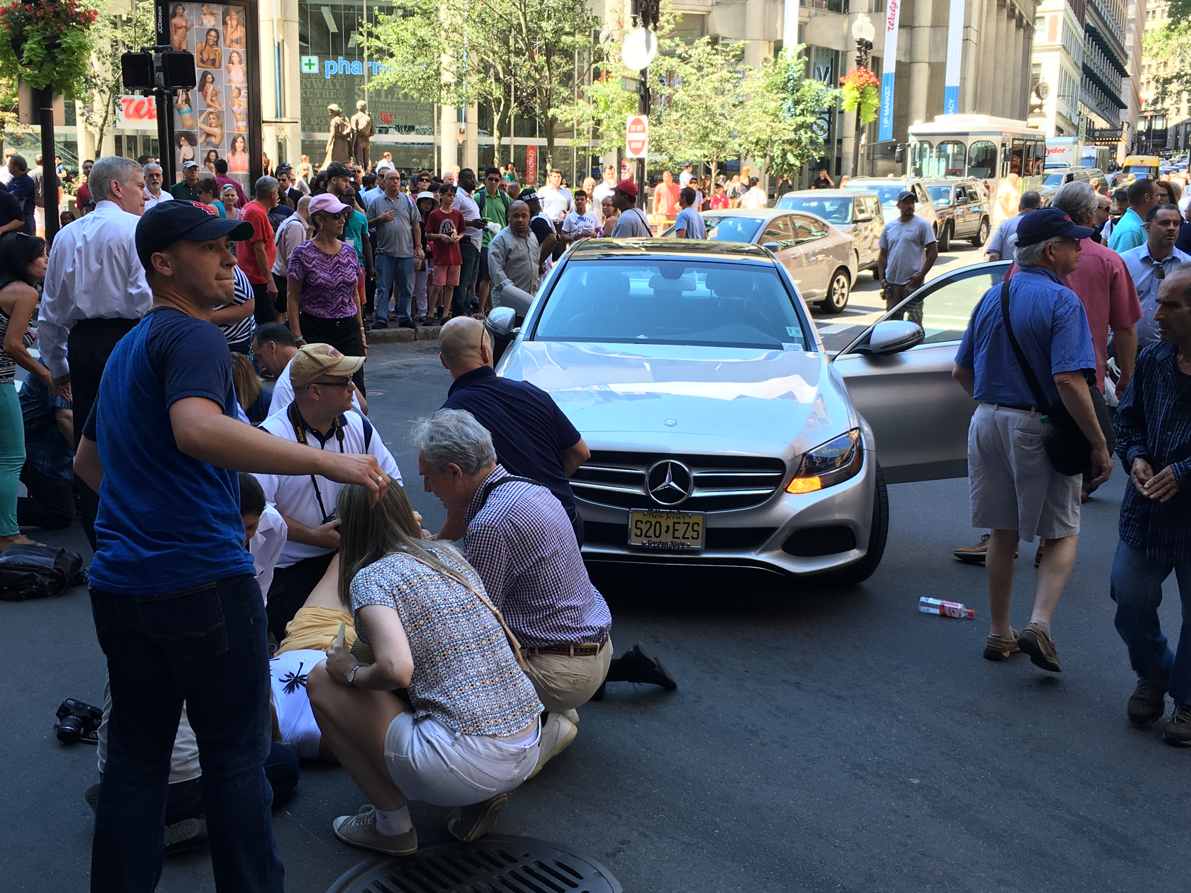 Bystanders surrounded a Mercedes-Benz that barreled into a group walking the Freedom Trail on Thursday.