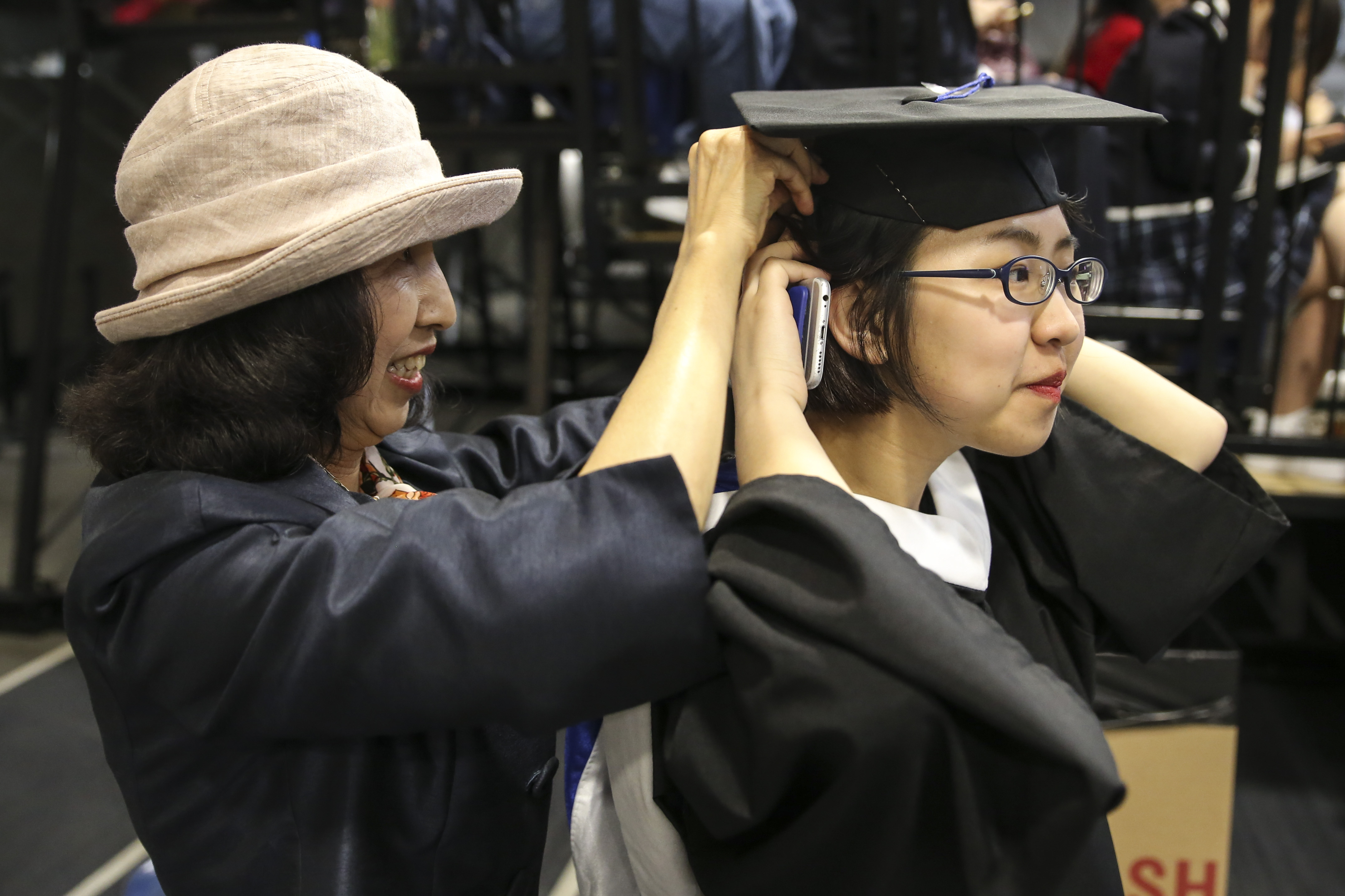 Shumei Ma helped her daughter, Meng Diao, adjust her hair and cap before the ceremony.