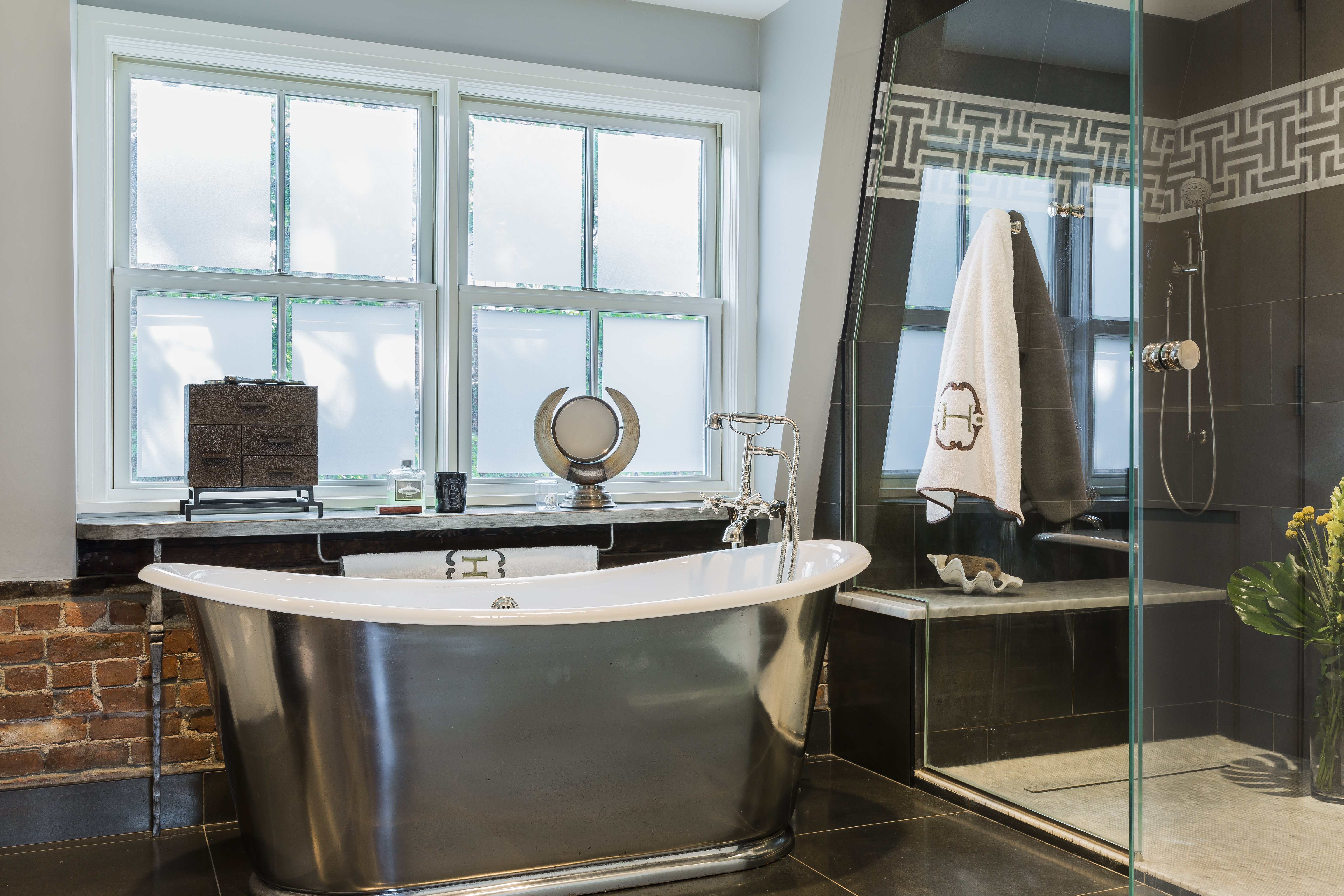 A band of Greek-key pattern tiles adds interest in the shower, big enough for two.