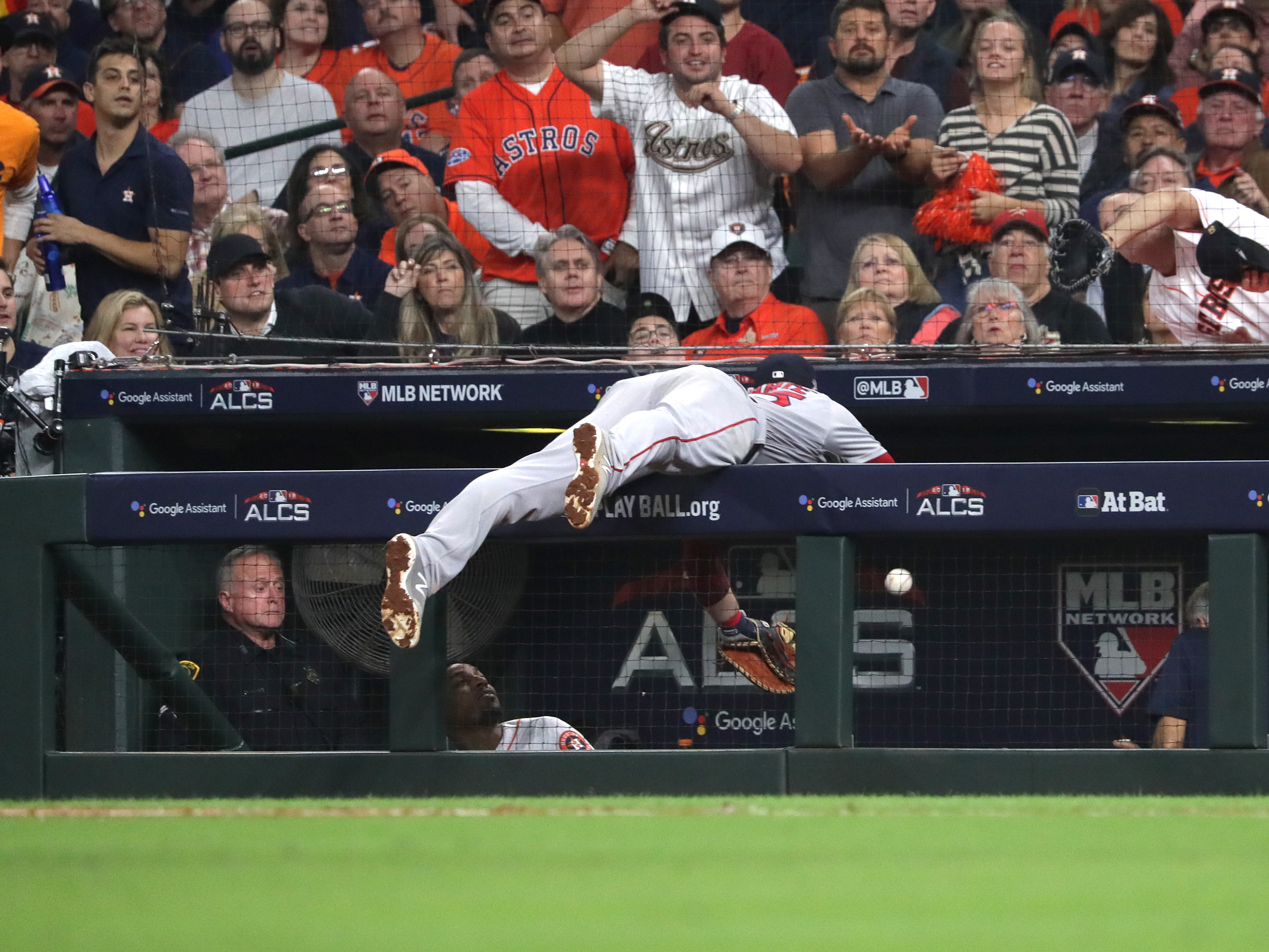 Steve Pearce goes after a foul ball in the seventh inning in front of the Astros dugout.
