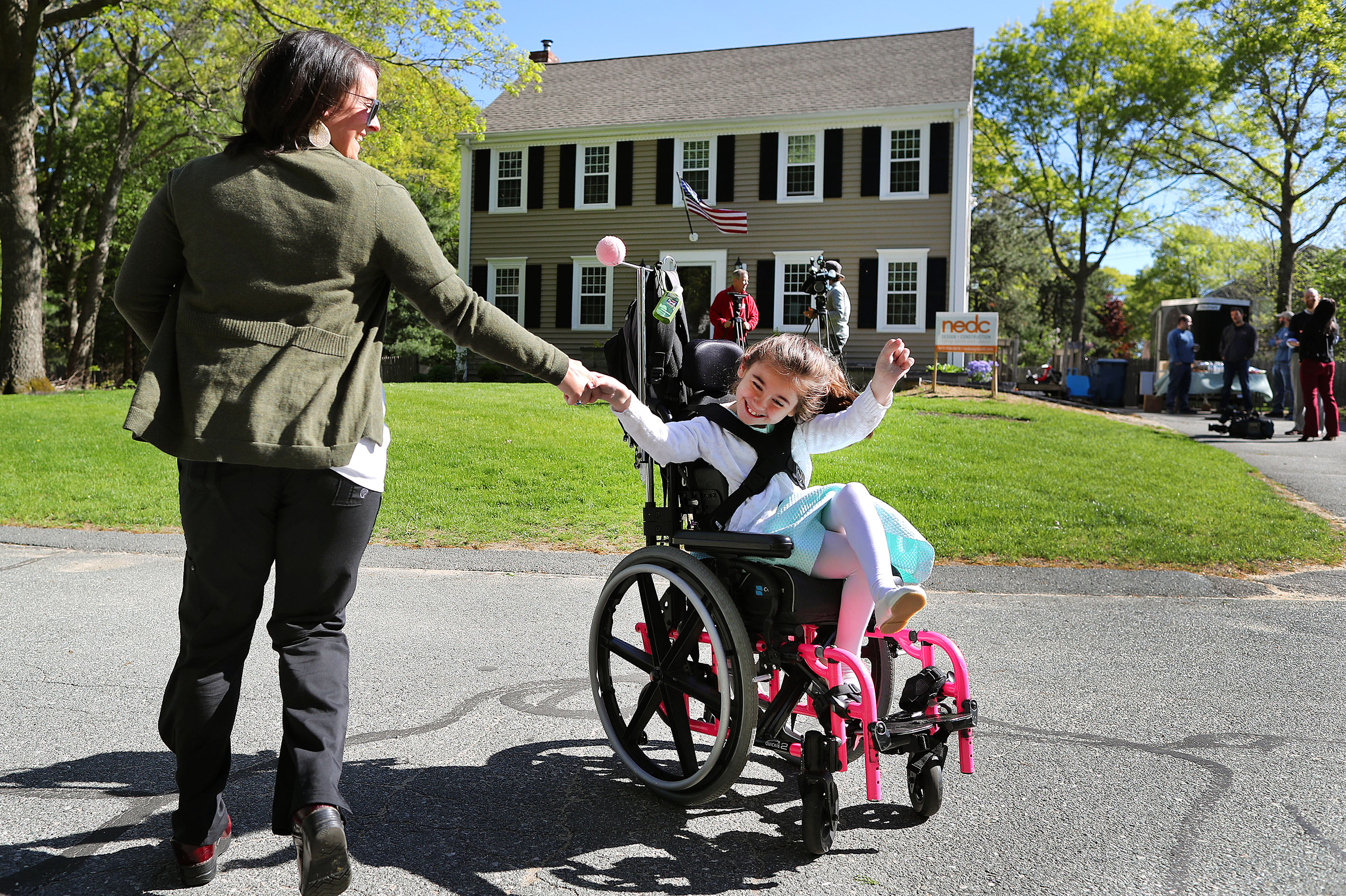 Abby spun around in her wheelchair with her nurse, Joy Giamo, in front of her renovated home before a ribbon-cutting ceremony.
