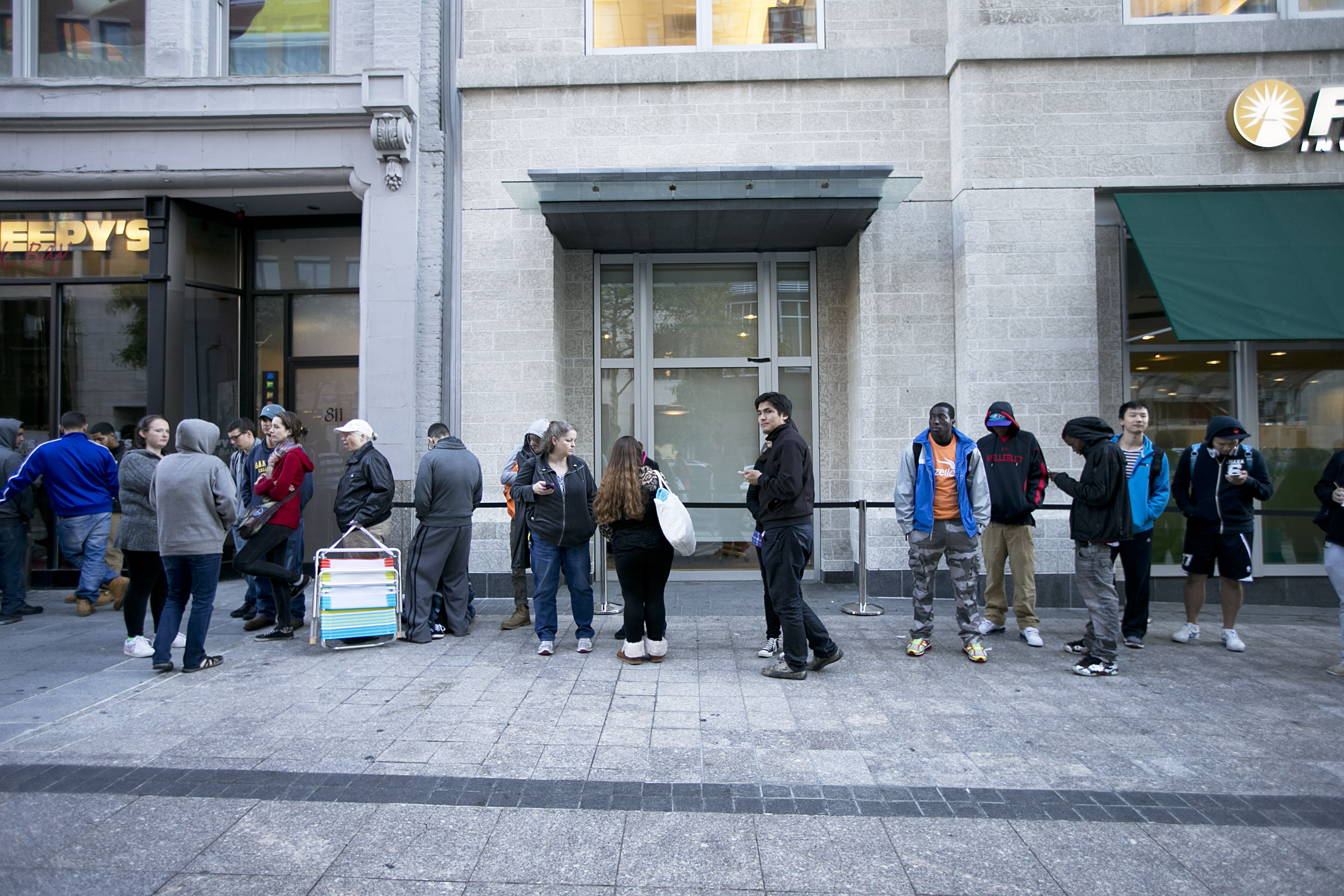 Consumers lined up for the new iPhones in Boston. With a two-year contract, the 5s costs $199 and the 5c is $99.