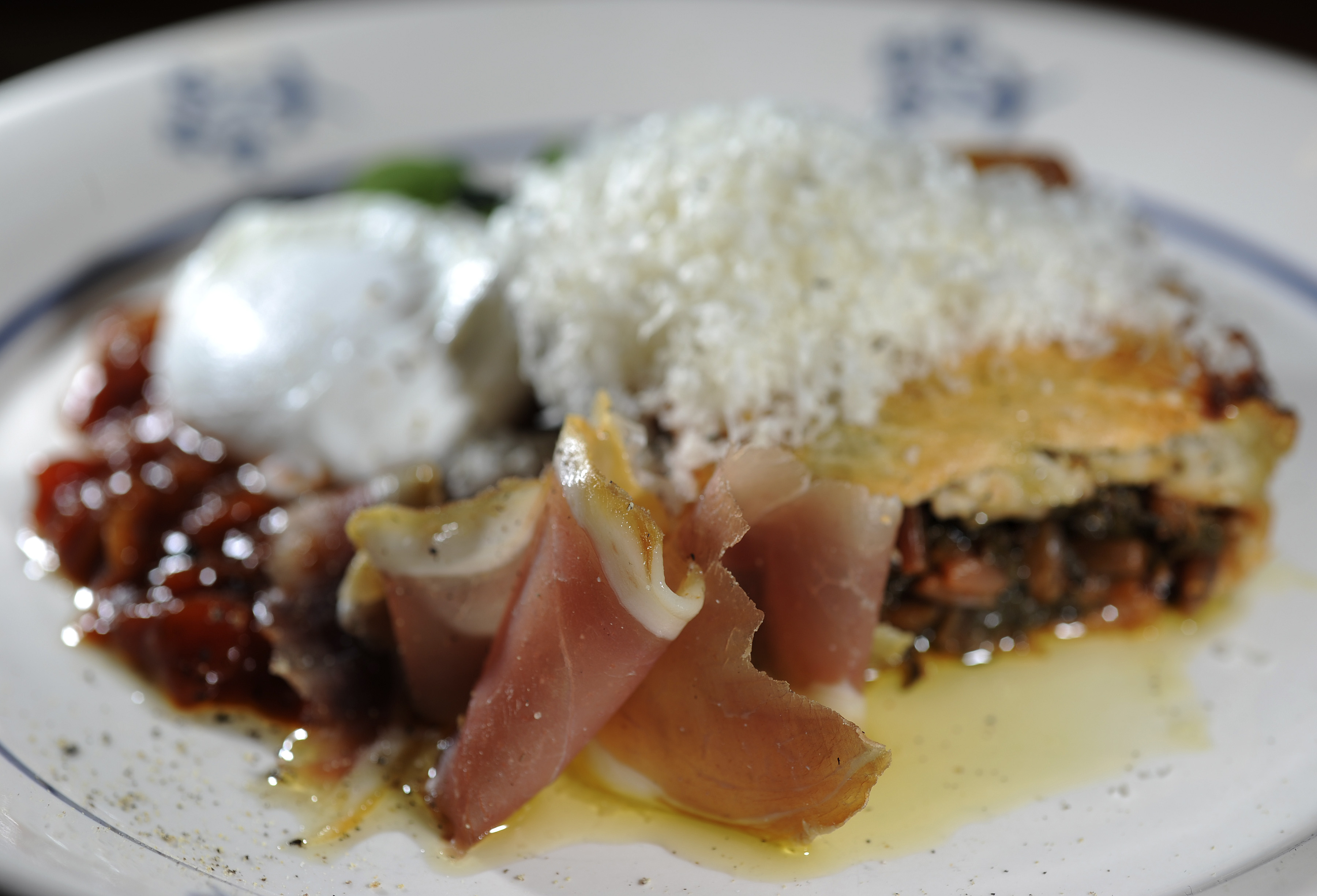 Swiss chard pie is served with colorado chile, Spanish ham, Basque piperade, and an egg.
