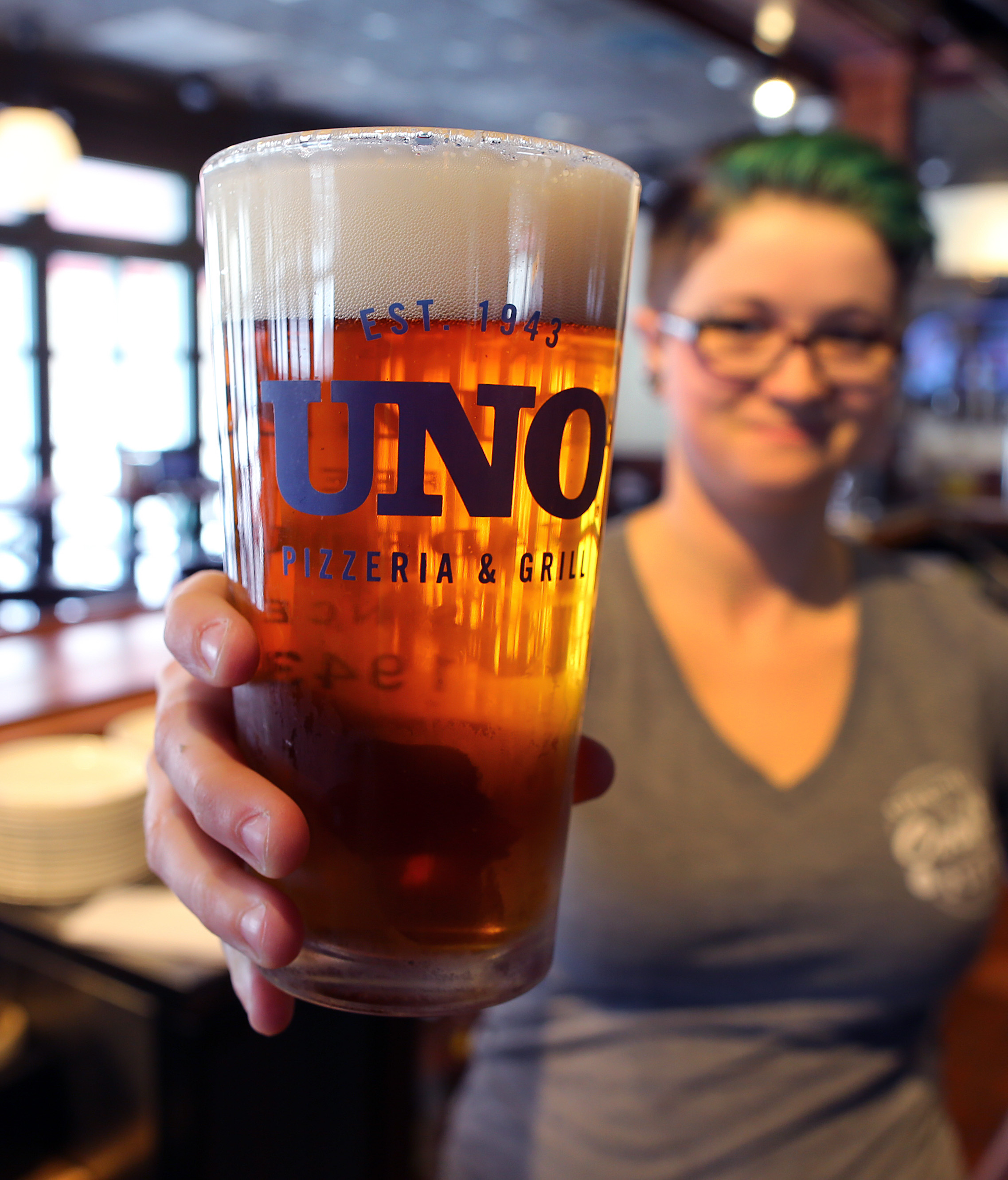 At the bar of Uno Pizzeria and Grill in Braintree, bartender Elise Verkade shows off one of 16 draughts the restaurant offers on tap.