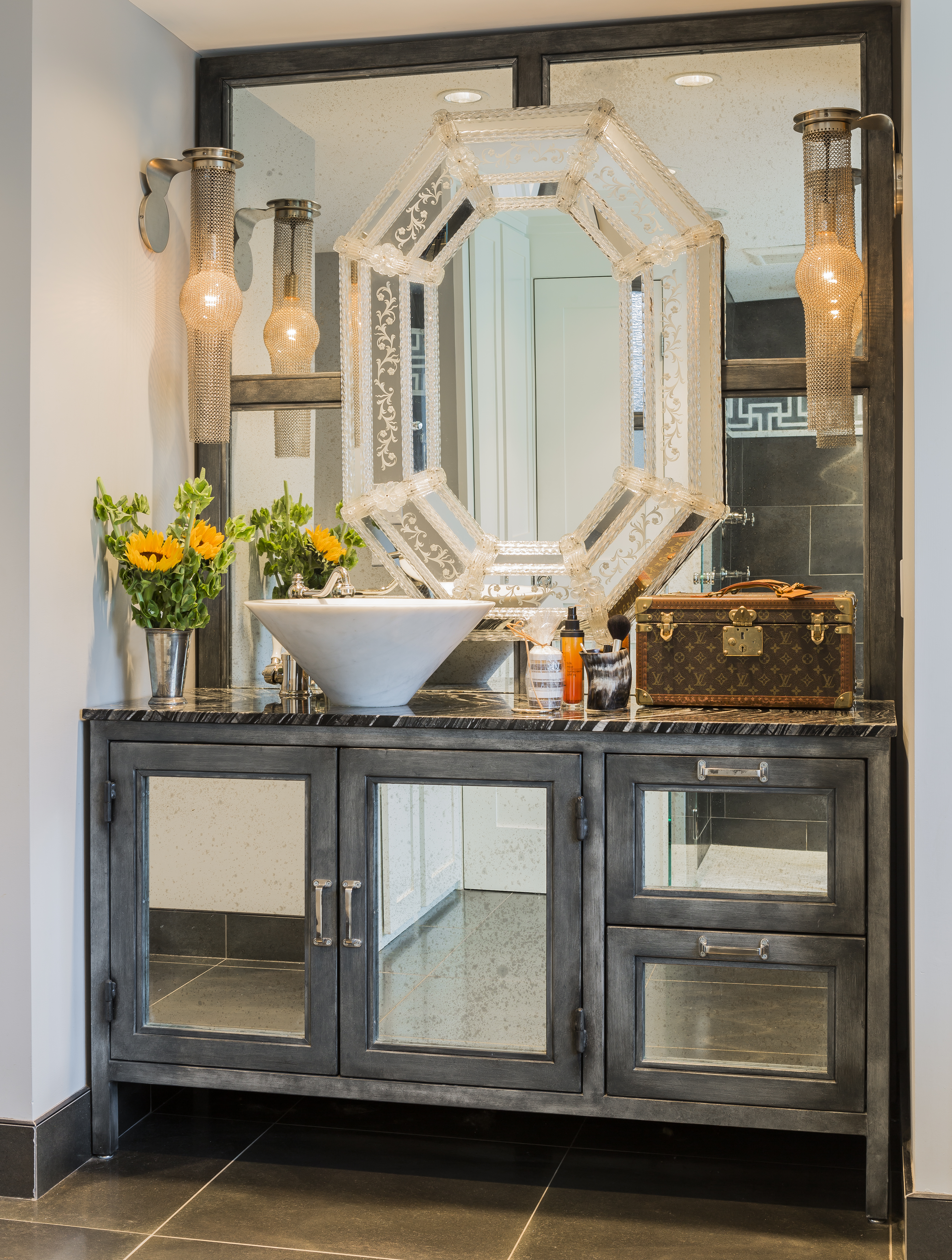 The custom vanity is made of industrial-grade steel, while an inset mirror, a family heirloom, adds a touch of the feminine.