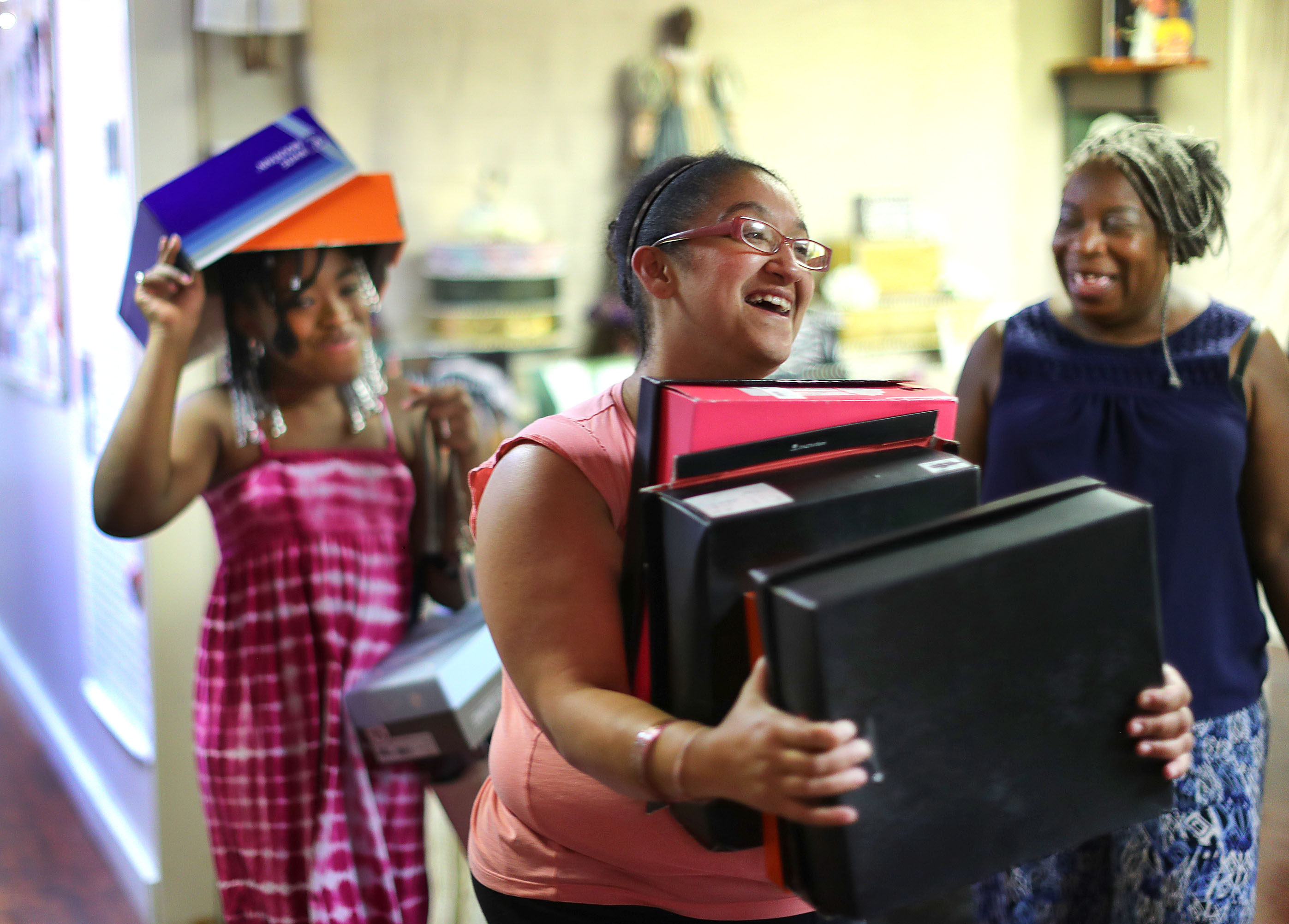 Volunteers Chaundra Butler, 11, and Jessica Gomes with shoe boxes, as they helped Debra Britt (right) construct a new exhibit.