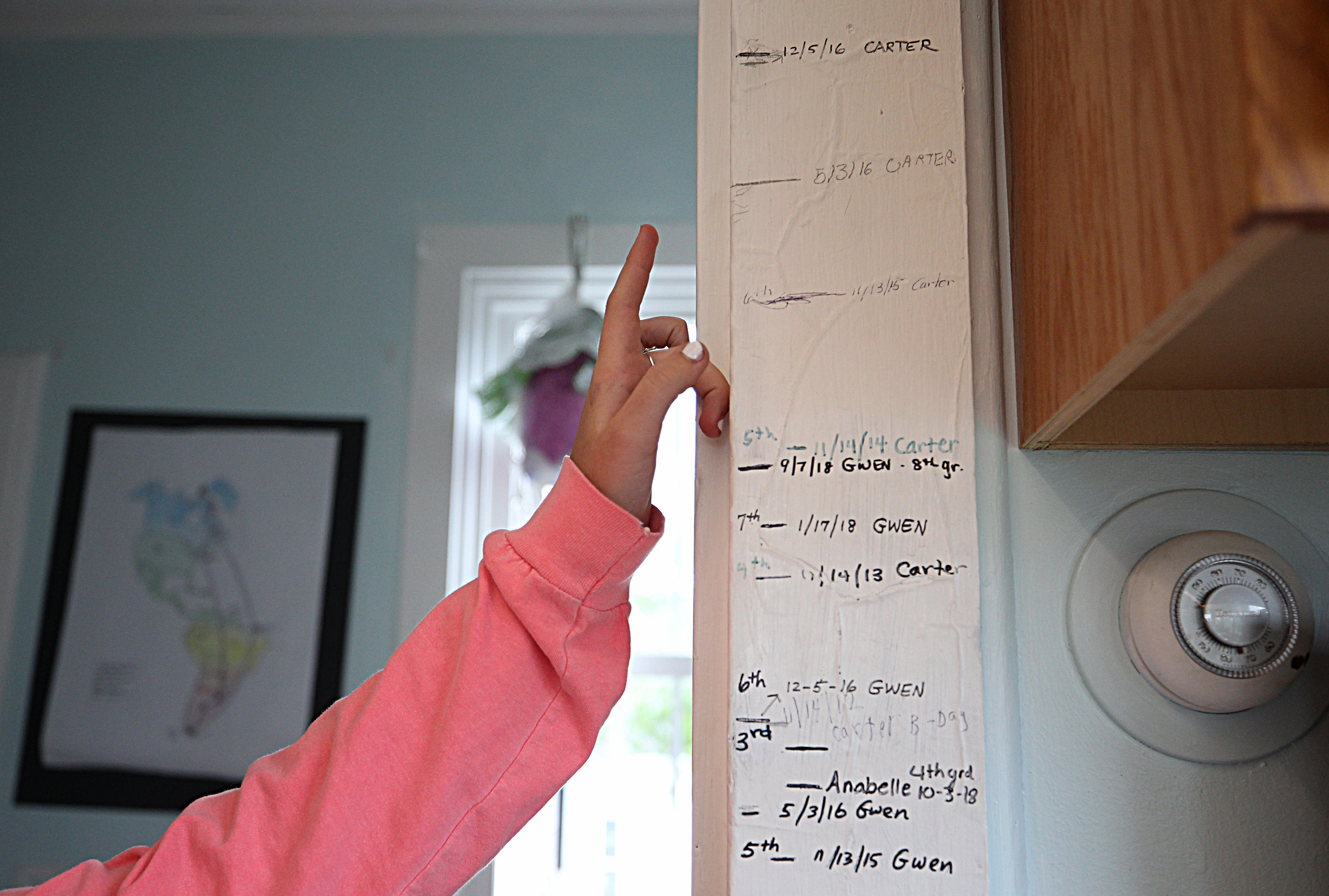 Gwen, her brother, and a handful of other students have had their height recorded on the schoolhouse walls.