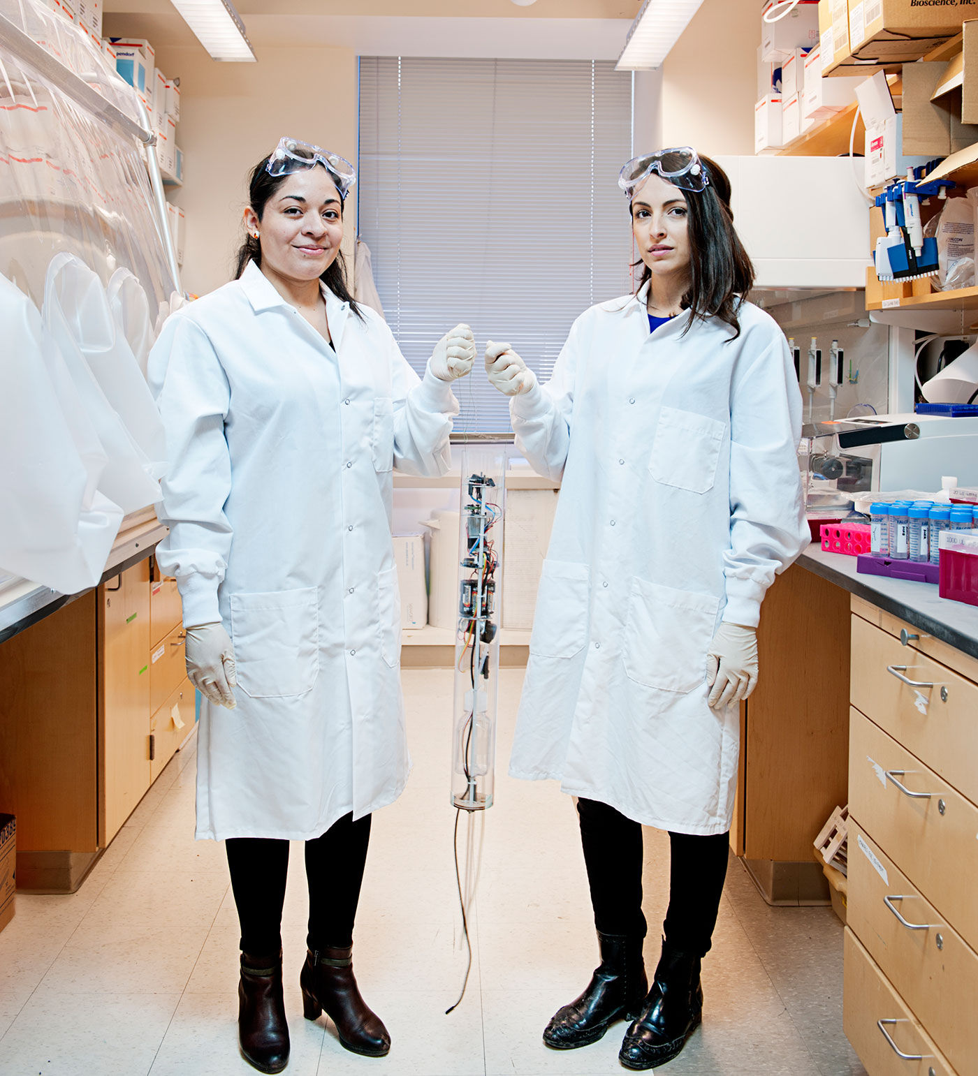 Mariana Matus (left) and Newsha Ghaeli with sewer-bot Luigi in the MIT lab where Matus analyzes its samples.
