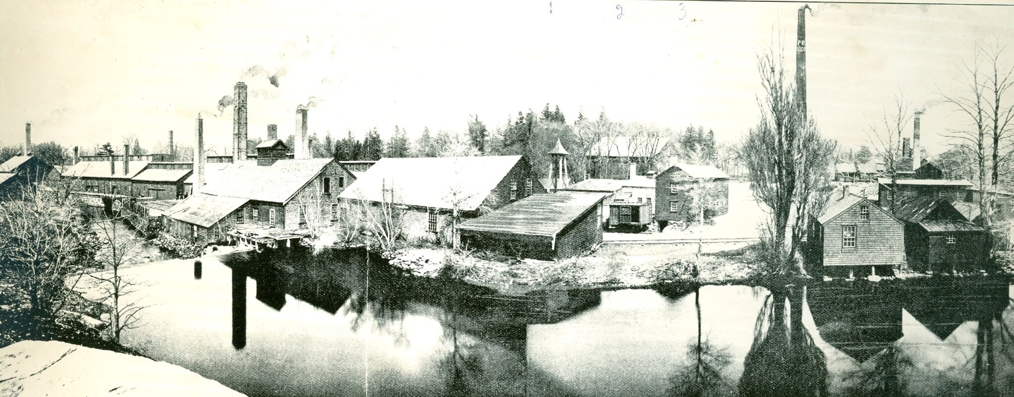 This photo, circa 1900, shows the copper yard and the east branch of the Neponset River, which is now buried on the site. The site once had many buildings, but they have nearly all been torn down, except for the mill and barn.