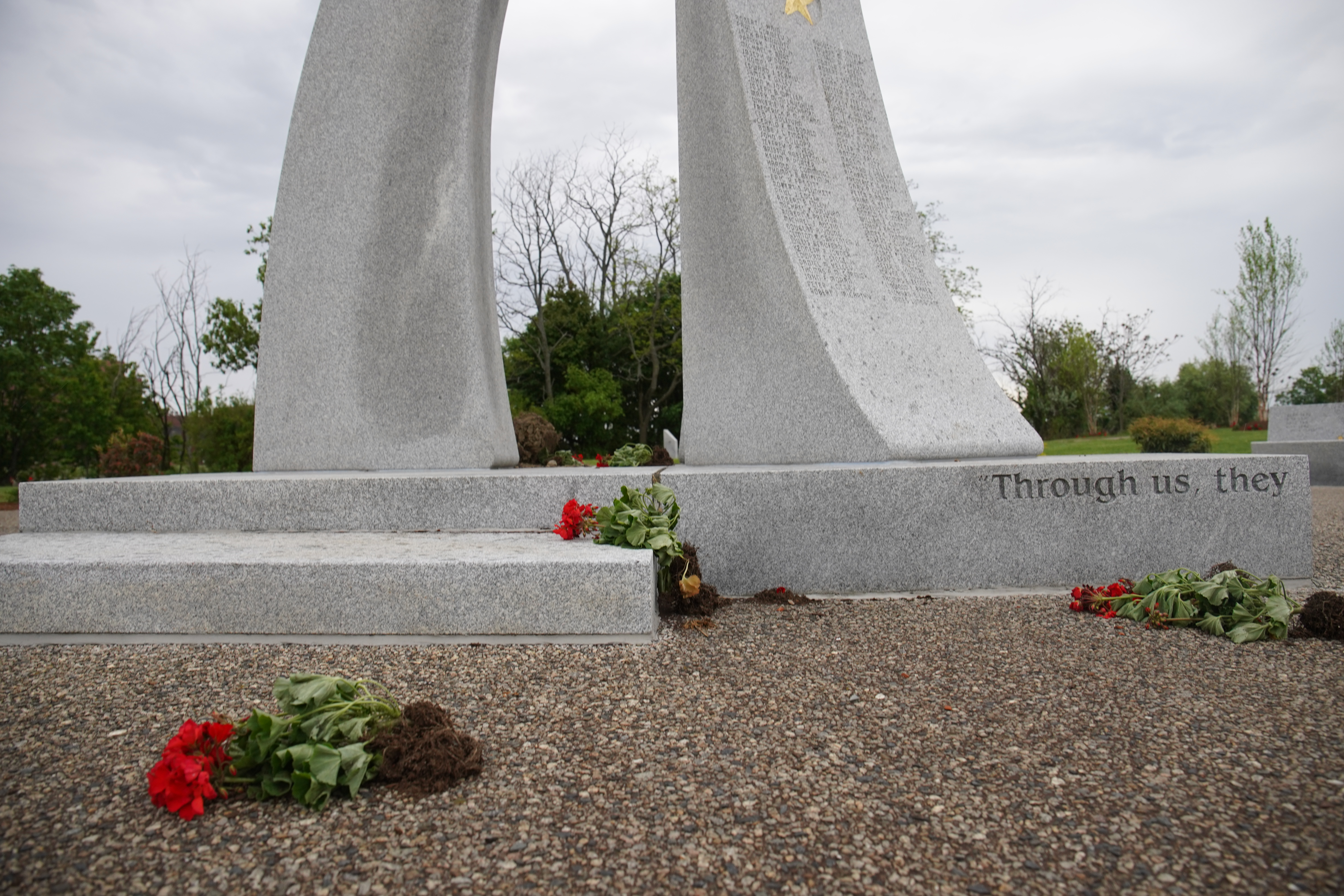 Previously potted flowers were tossed on the ground near the memorial.