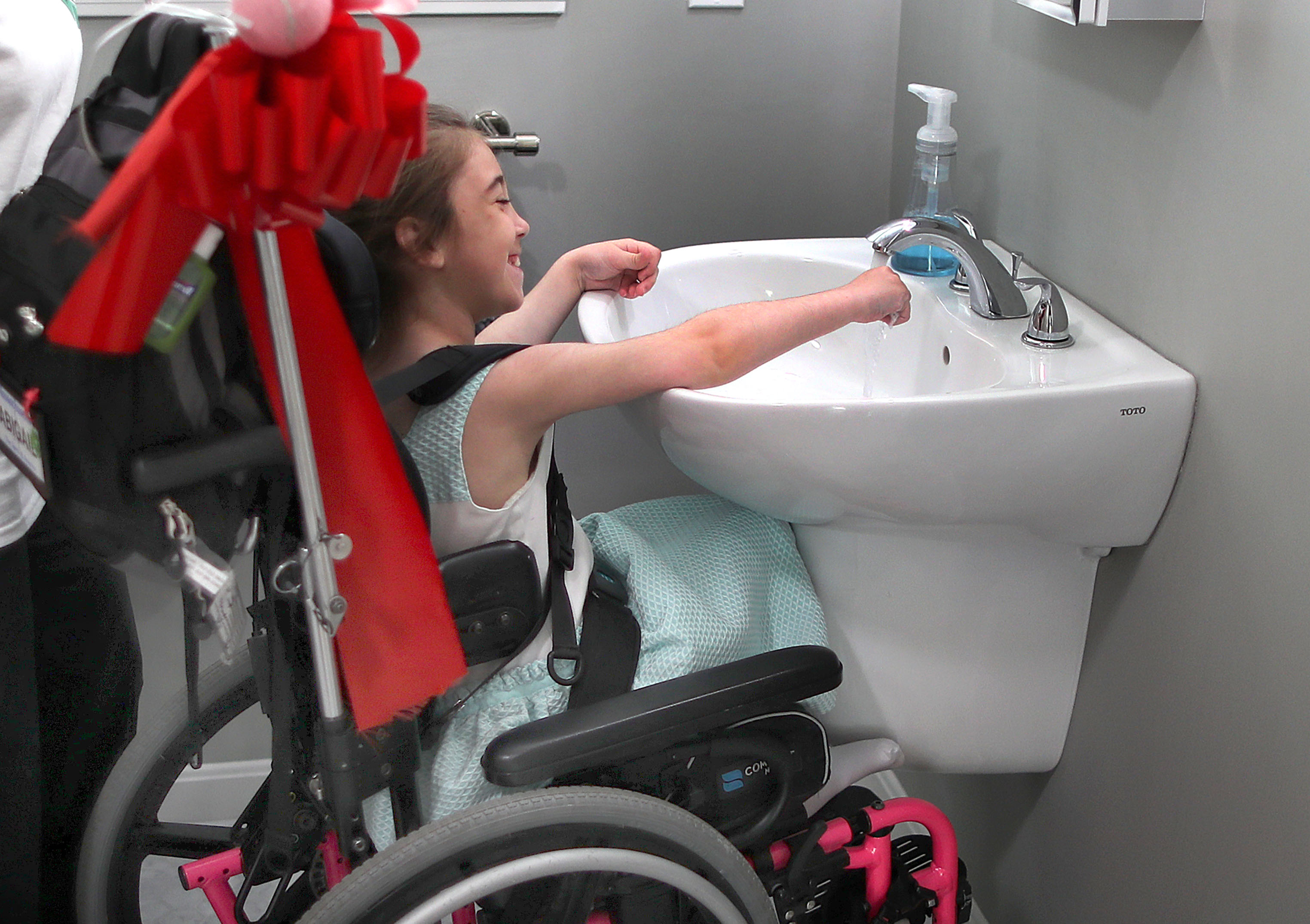 Abby washed her hands in the new accessible bathroom sink.