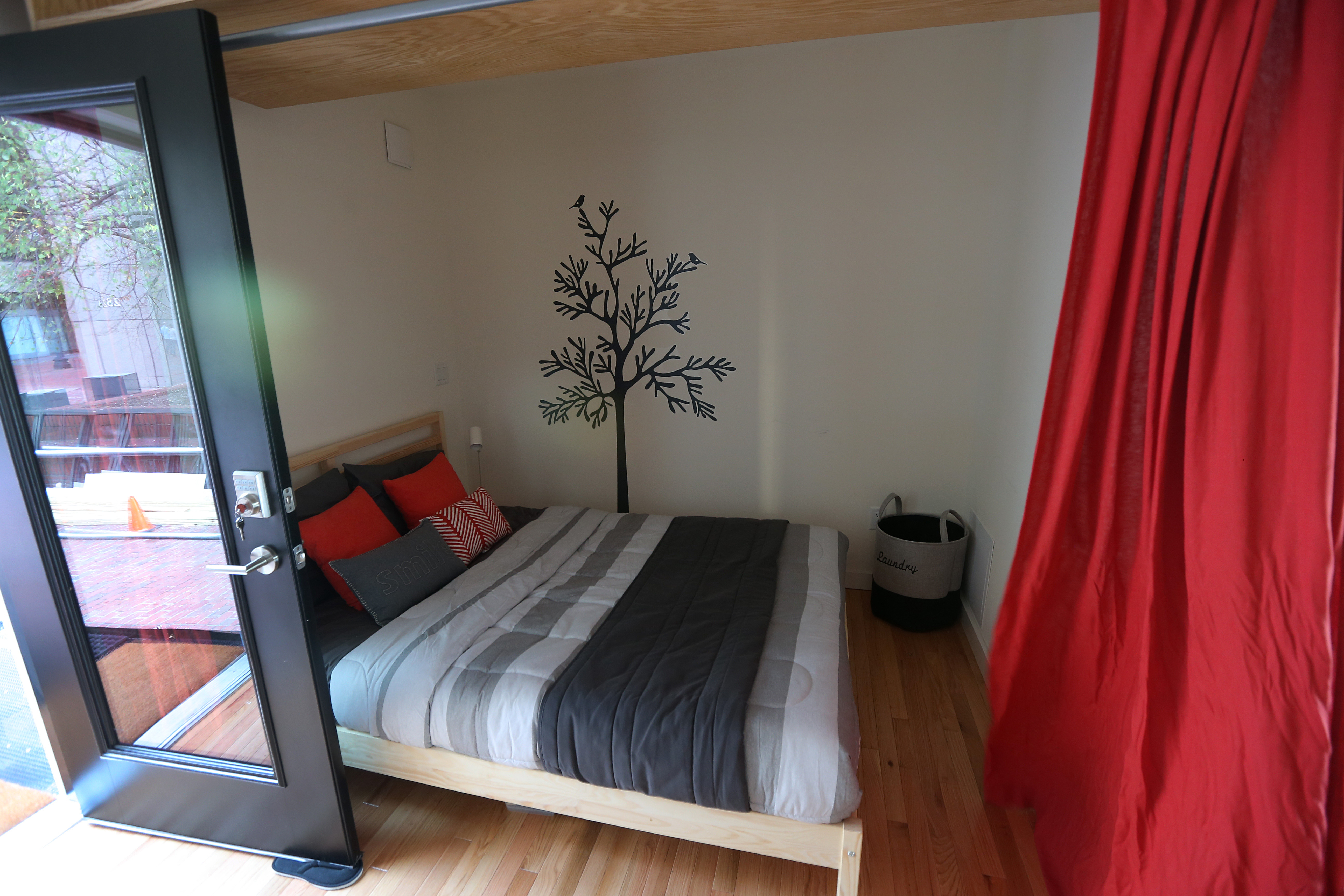 The uHu’s bedroom has a curtain for privacy, or as much privacy as a 385-square-foot apartment can offer.
