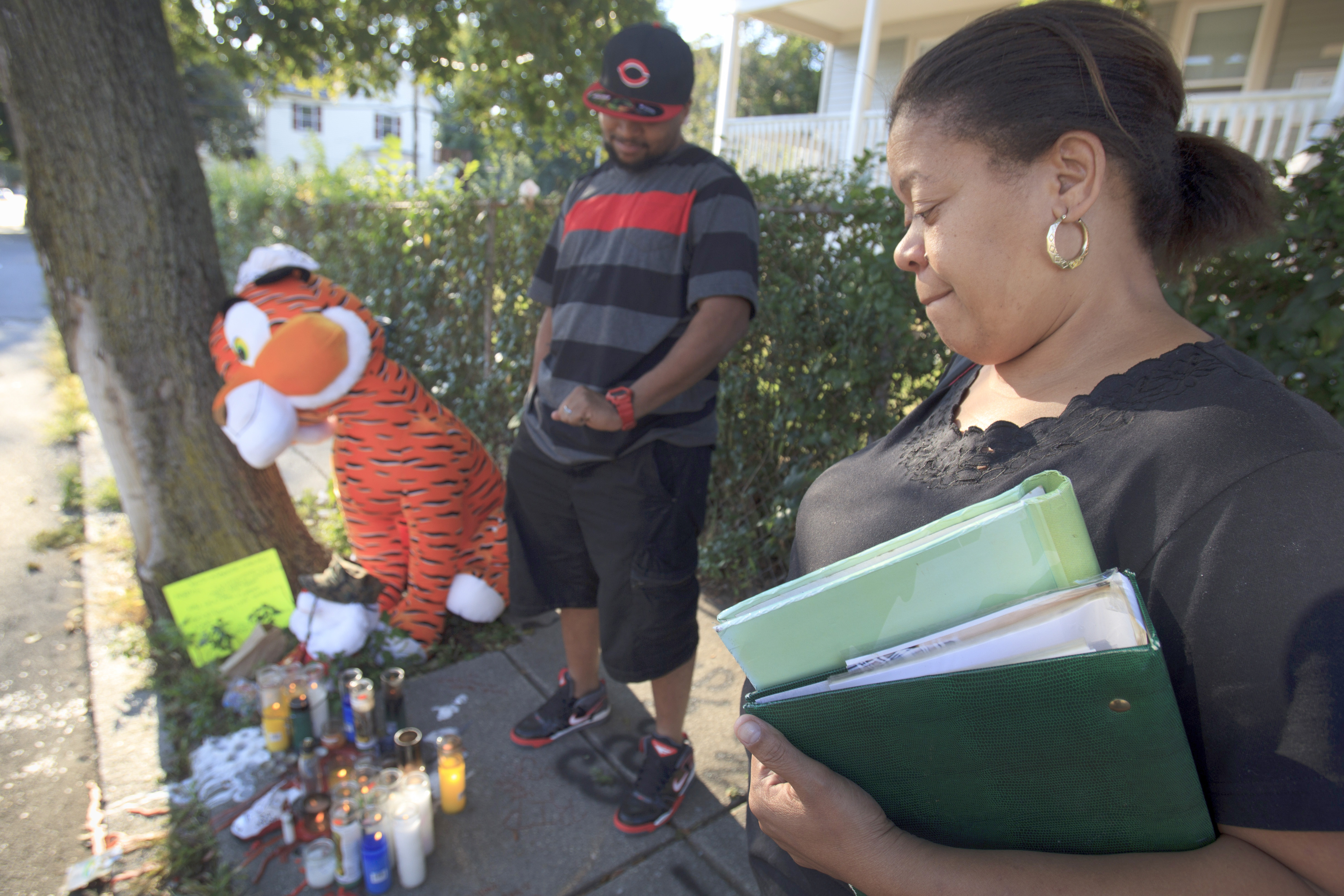 Mirna Luz Ramos visited a makeshift memorial for her son Jorge Fuentes as another son, Carmelo Fuentes, looked on.
