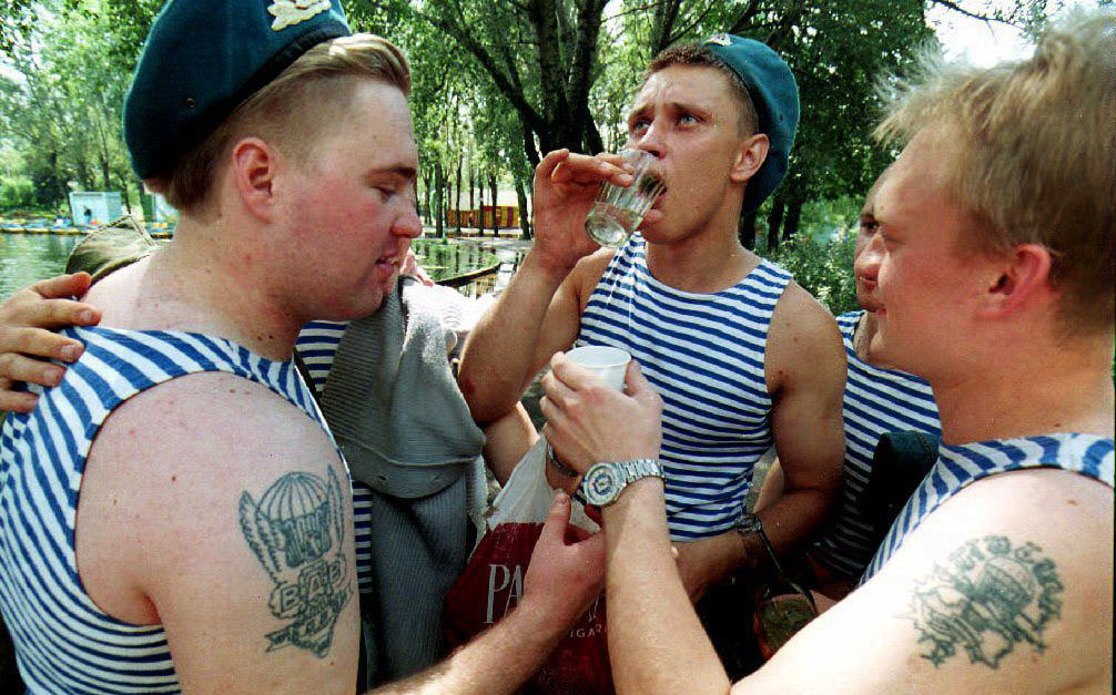 Three Russian paratroopers drink vodka, celebrating National Paratroop Day in Gorky Park in August 1993.