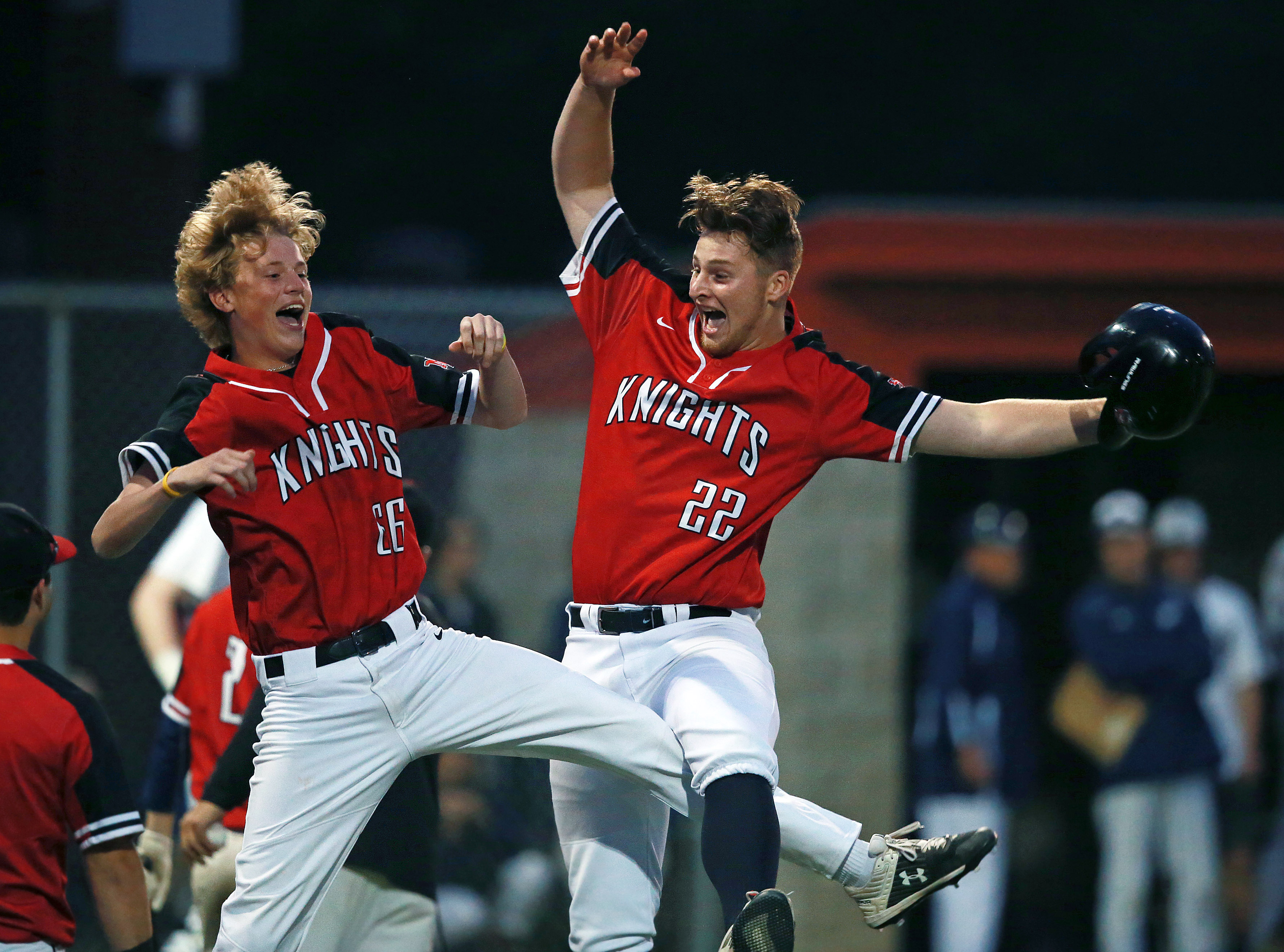 North Andover's Eric Whitehead (right), who had just hit a sixth inning RBI double to put his team ahead, 2-0, is greeted by a leaping teammate Ryan Griffin when he came back to the dugout after being lifted for a pinch runner.