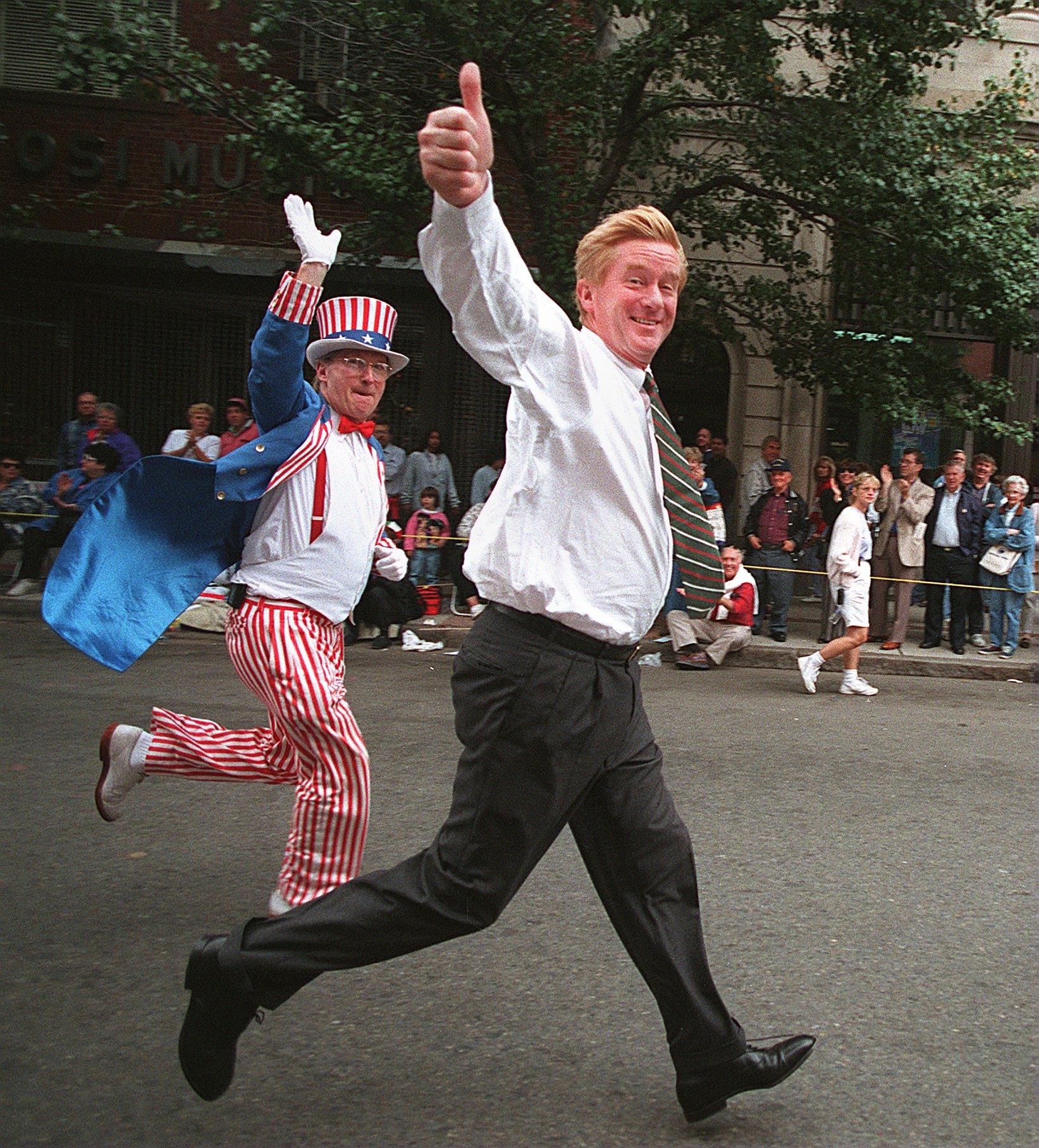 Weld, shadowed by “Uncle Sam,” sprints up Hanover Street in the North End during 1995’s Colombus Day parade.