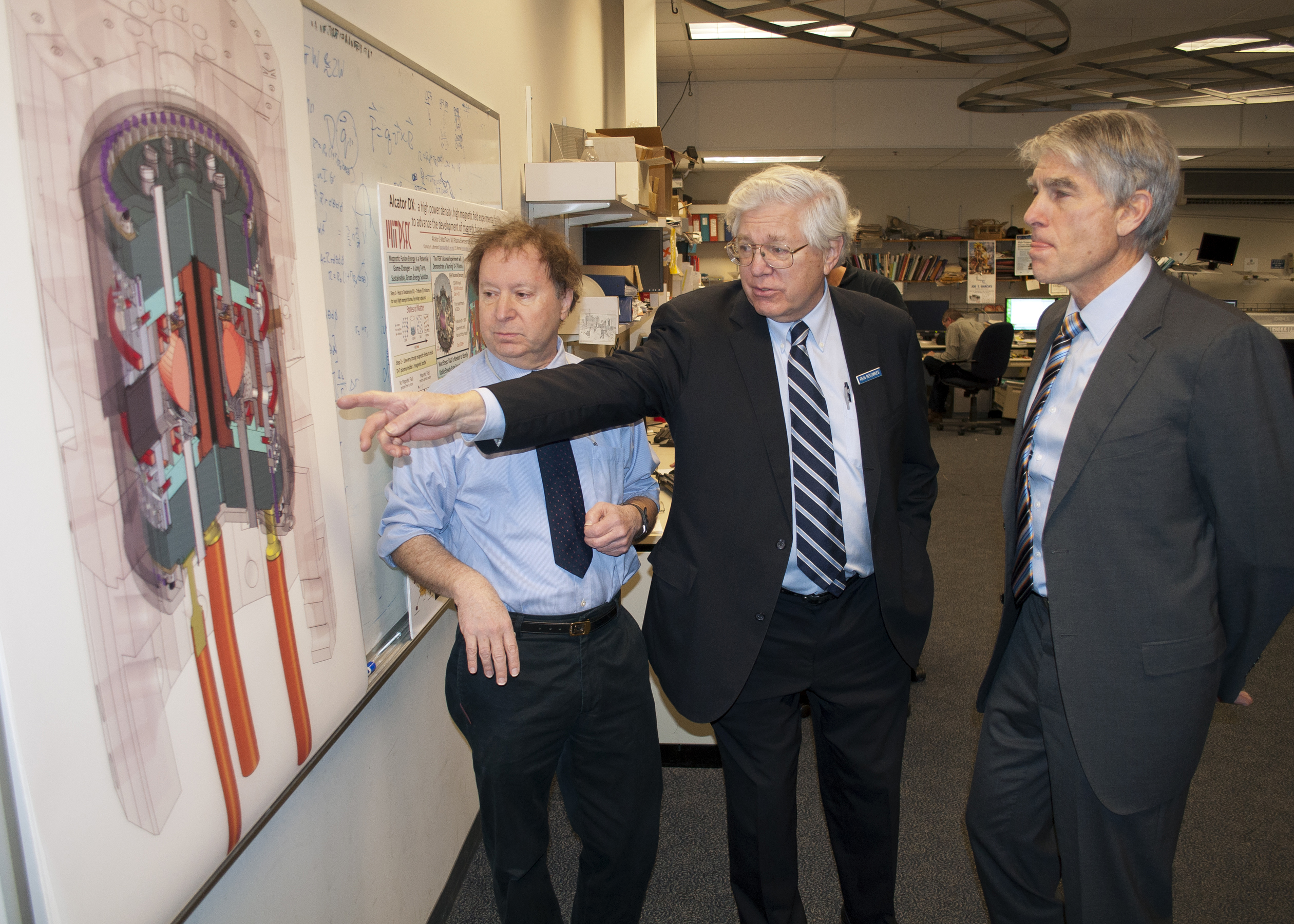 Reinier Beeuwkes (center) discussed a diagram of the Alcator C-Mod reactor during a tour at MIT with Senator Mark Udall of Colorado (right) and Martin Greenwald, associate director of the fusion center.