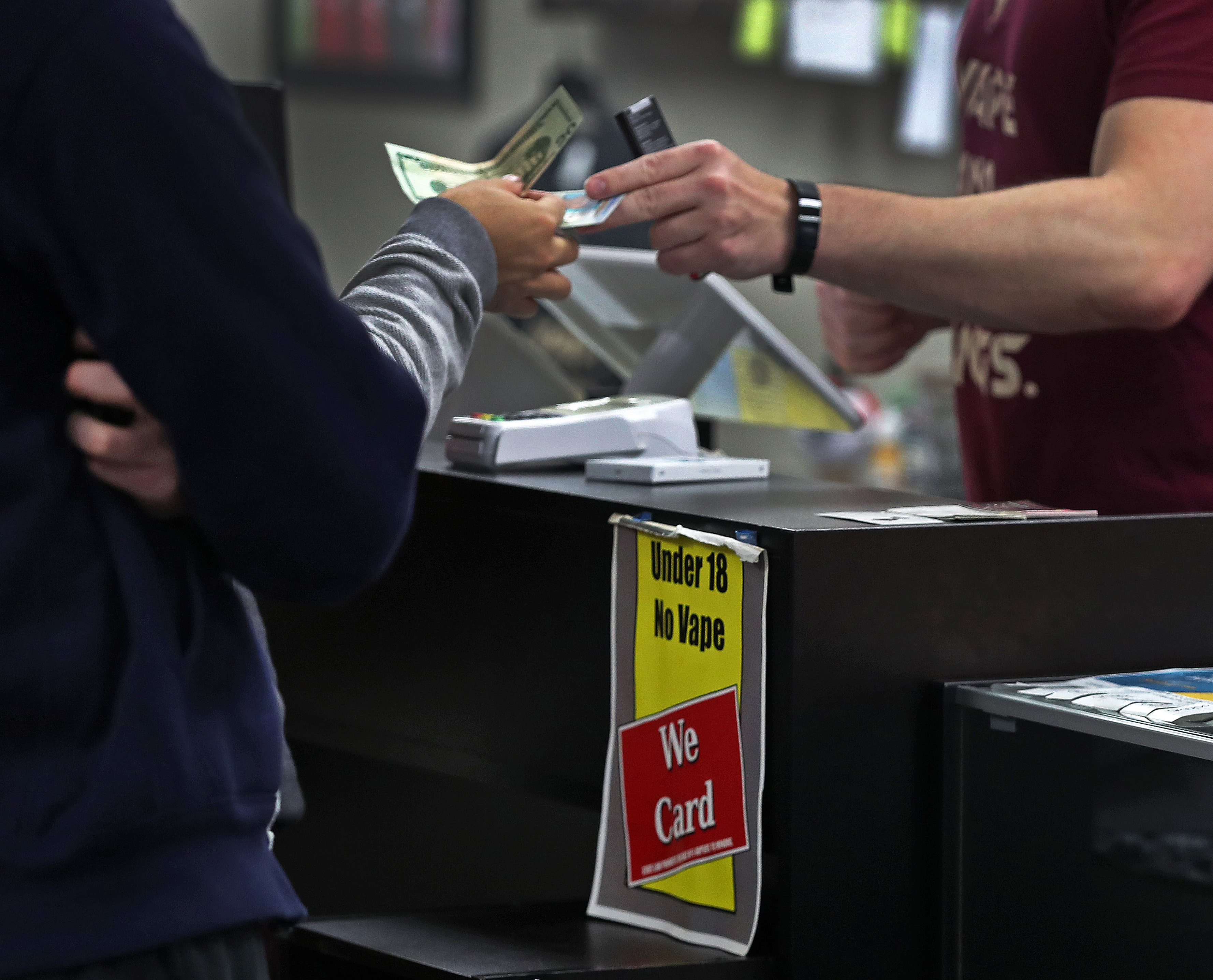 Ken Irons (right) checked the ID of a customer.