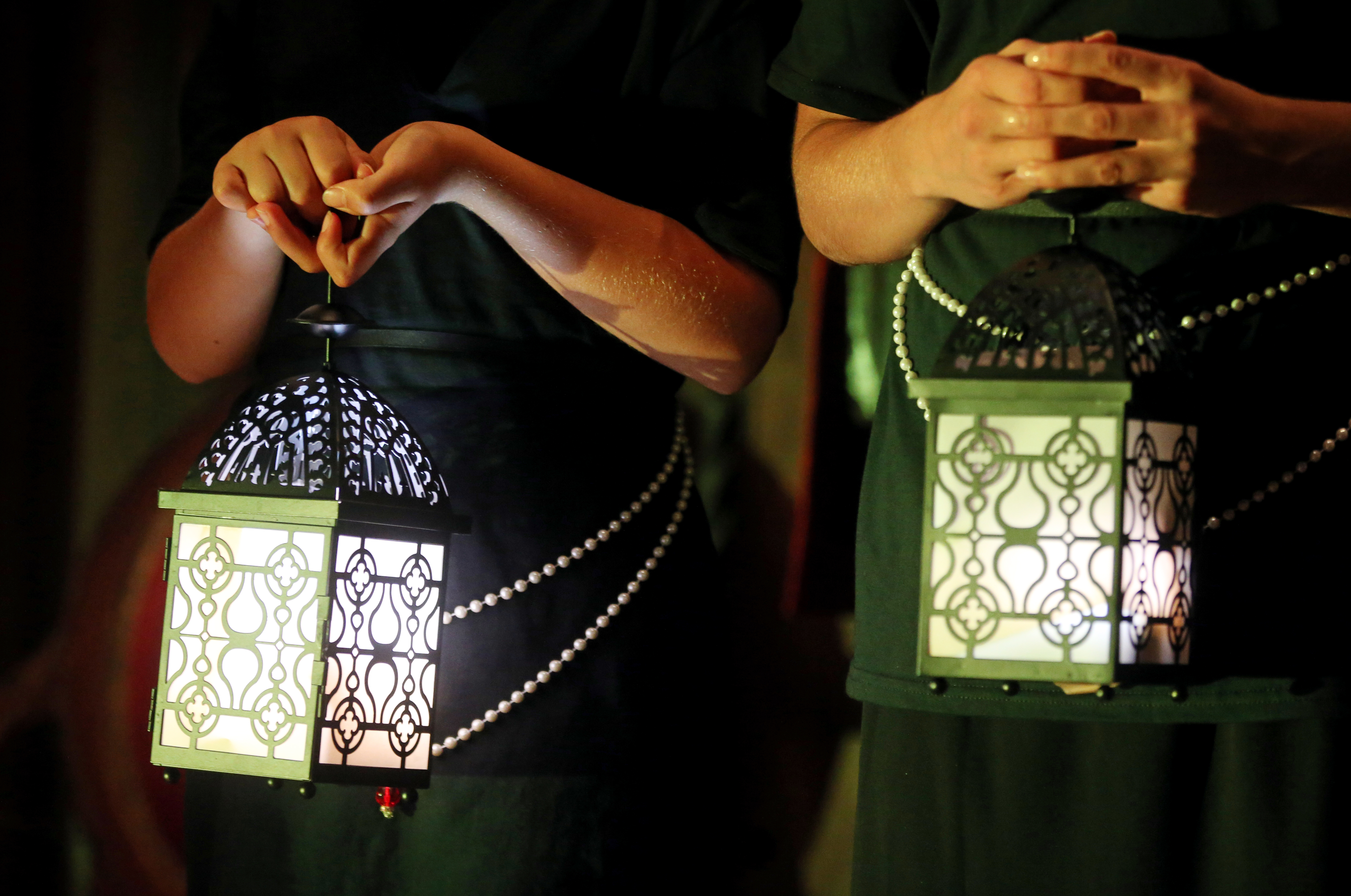 Isabella Choir members use lanterns to guide tours during a rehearsal of “Dancing Through the Galleries.”