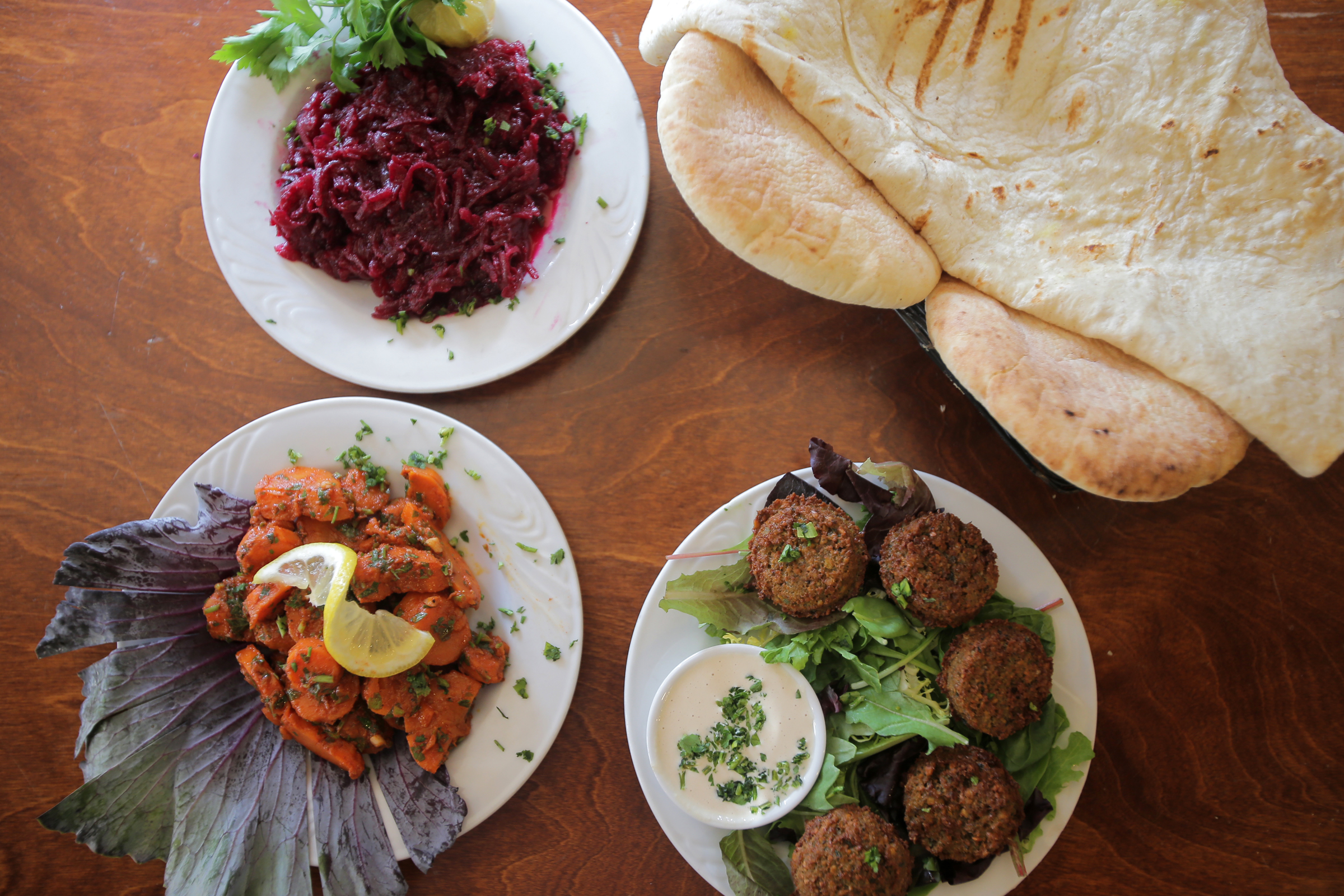 Cumin scented beet salad, Moroccan carrots, falafel, and pitas and laffa bread at Jerusalem Pita in Brookline.