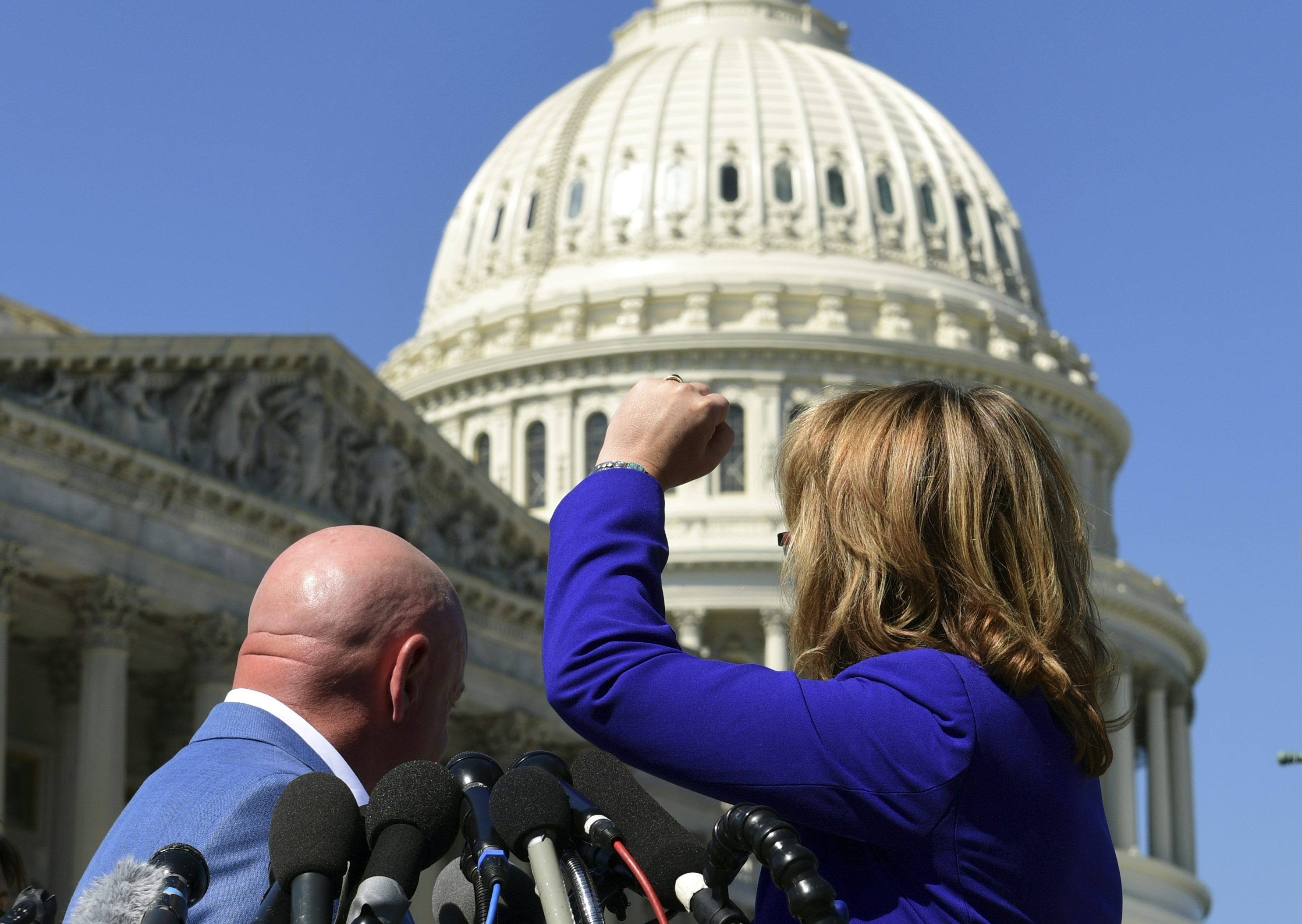Former Rep. Gabrielle Giffords, right, shook her fist at the United States Capitol as she and her husband, Mark Kelly, left, spoke on Capitol Hill in Washington.