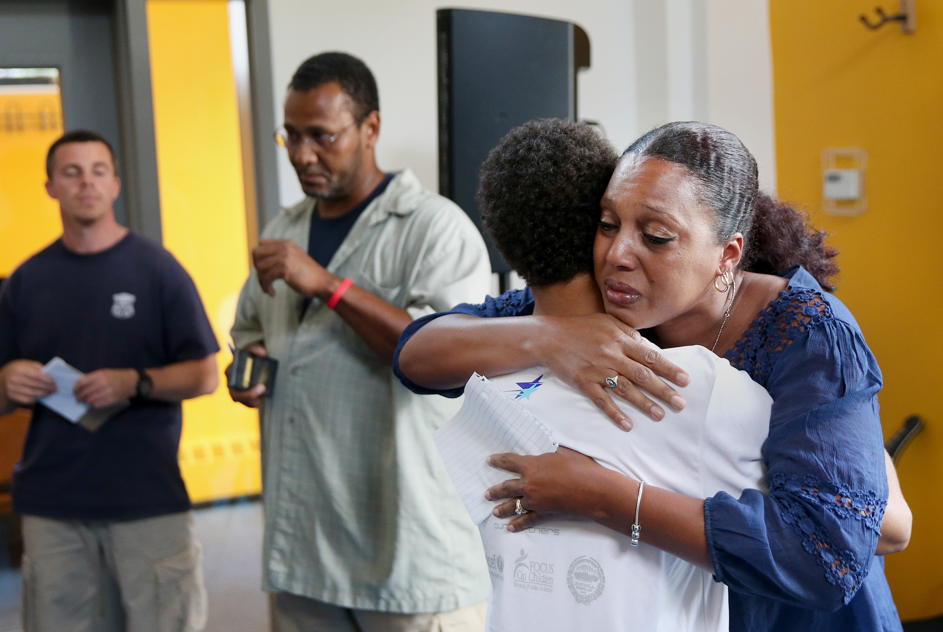Boston police officer Kim Tavares (right) hugs Chris Kenney, 19, of Dorchester, after Tavares teared up while talking about what she wishes city residents knew about her.