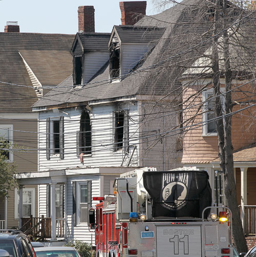 Boston fire crews and police stood by at the scene of a fatal three-alarm fire at 87 Linden St. in Allston on Sunday.