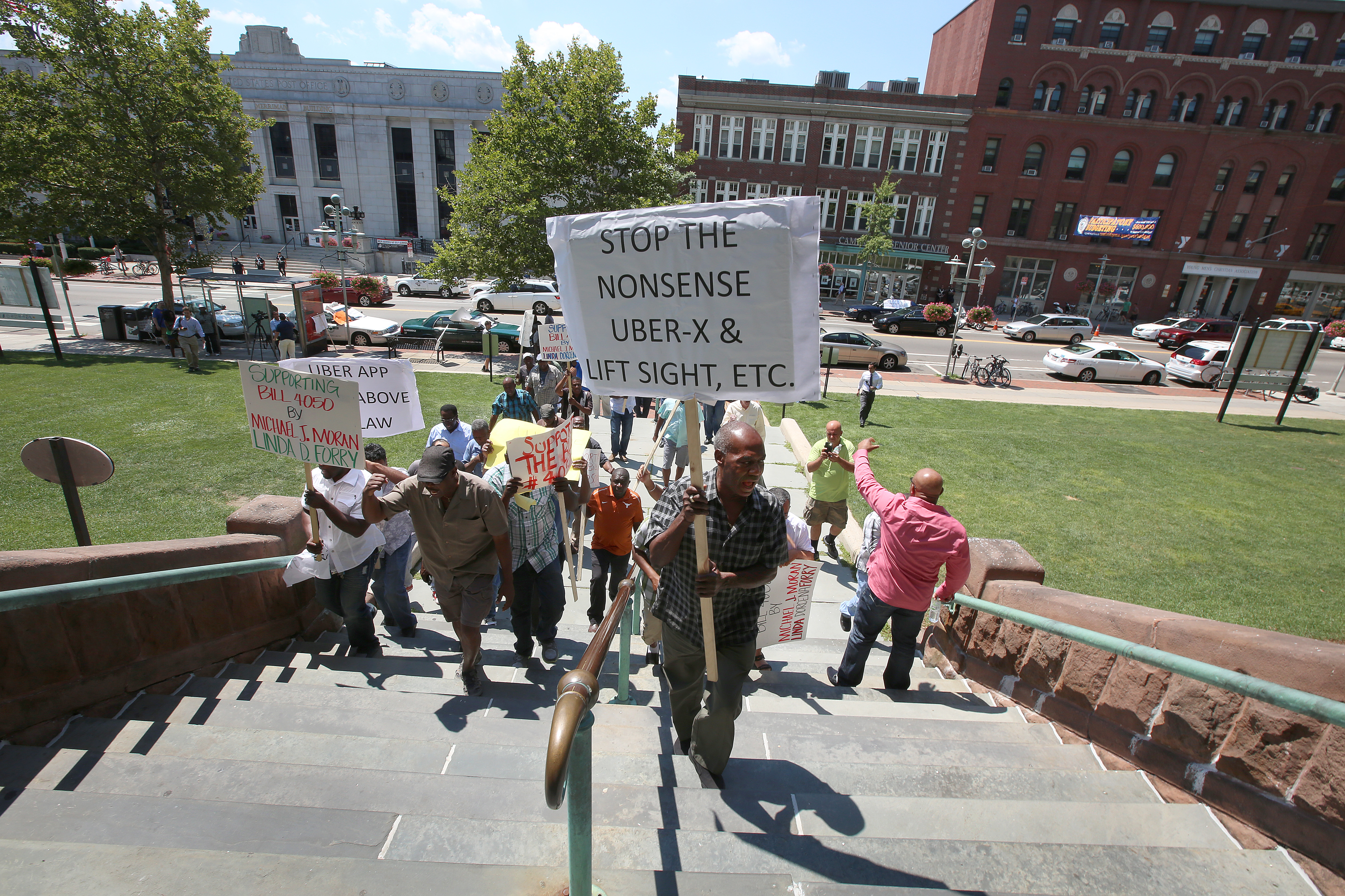 Taxi drivers marched up the steps of City Hall in Cambridge on Monday as part of a one-day strike, chanting their displeasure over Uber and other ride-hailing services.