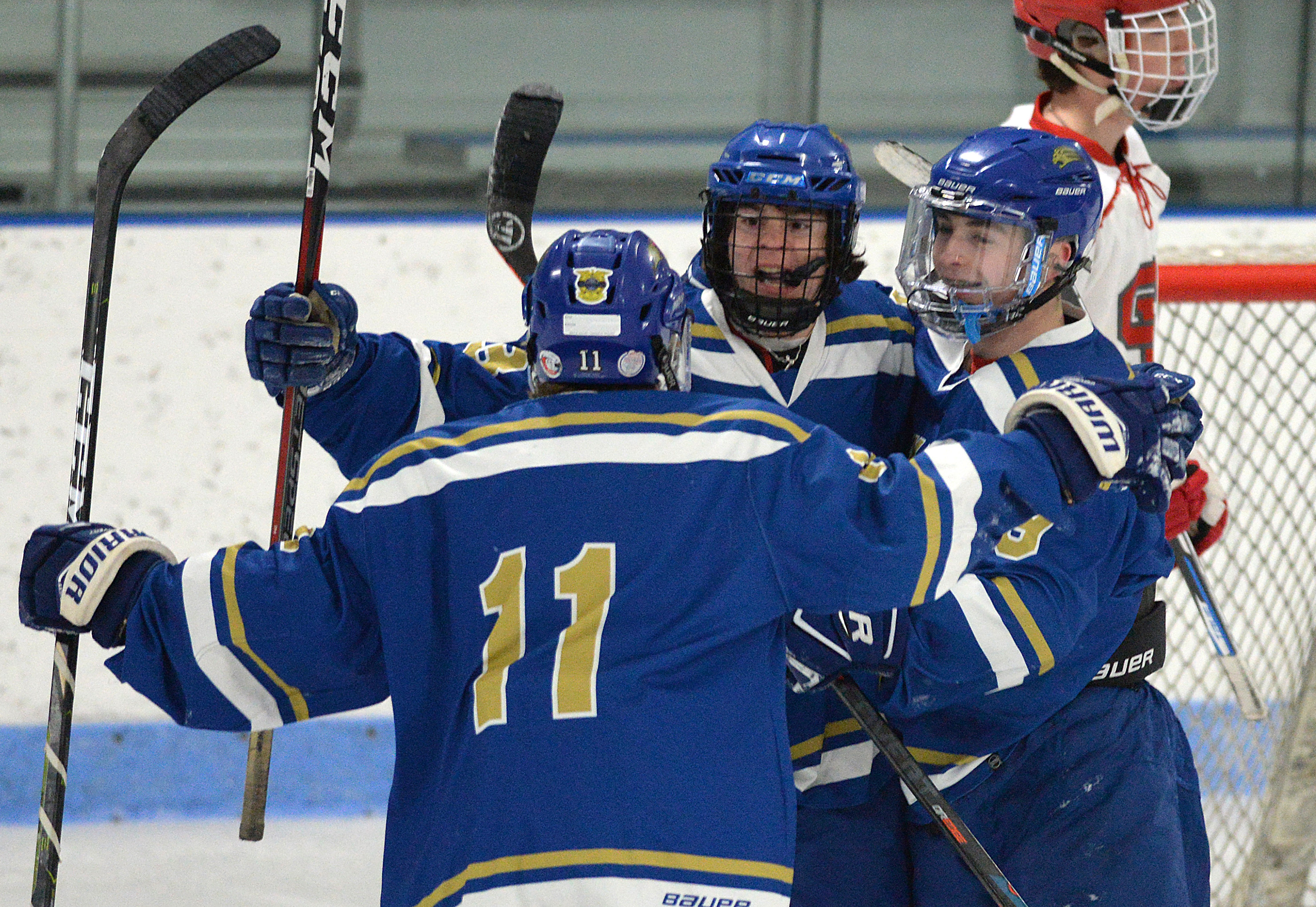Charlie Baroni (11) celebrates his first-period goal vs. Silver Lake with St. John Paul II teammates Sam Delman (center) and Michael Kornek (right).