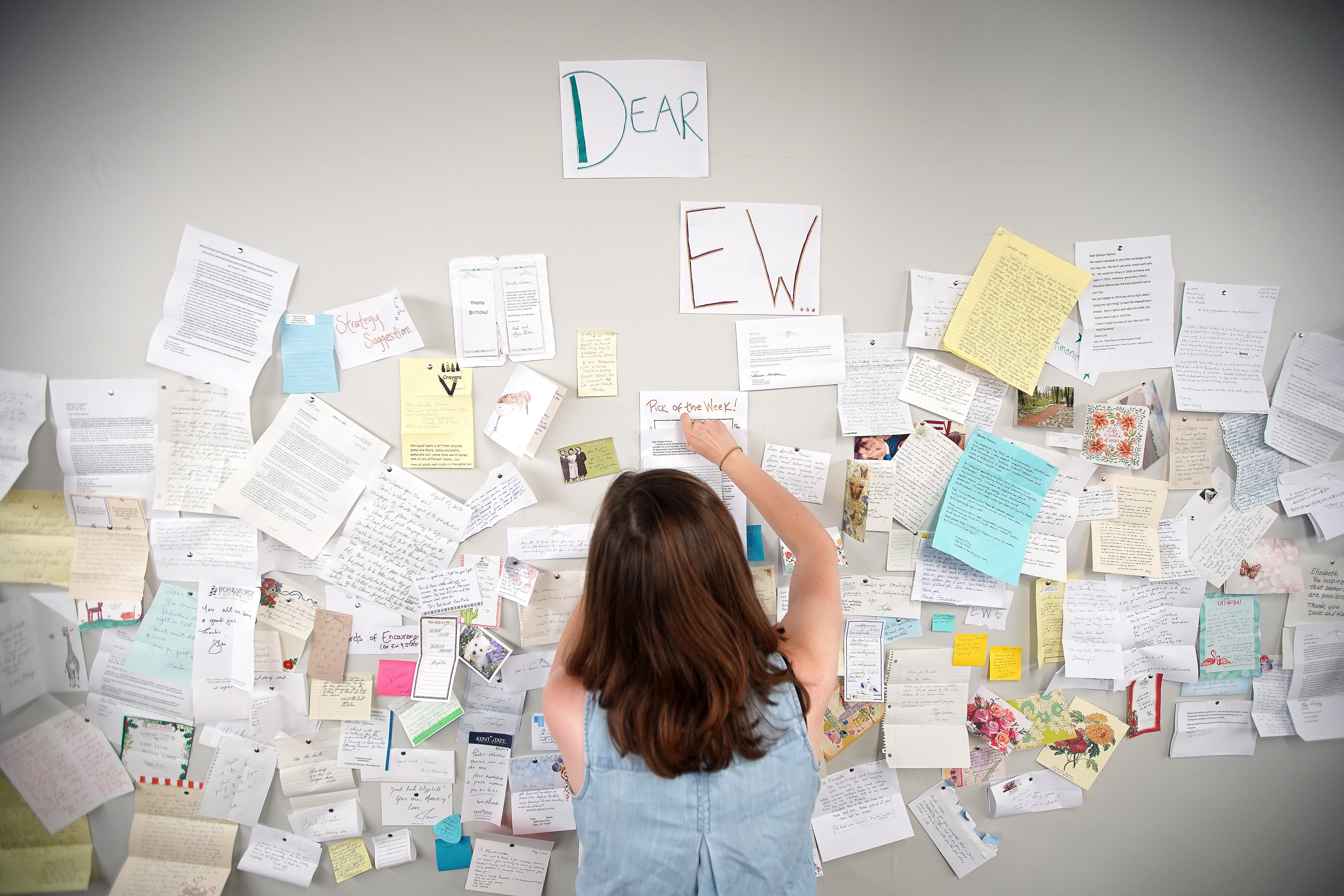 A wall of the office contains snail mail letters that Warren receives.