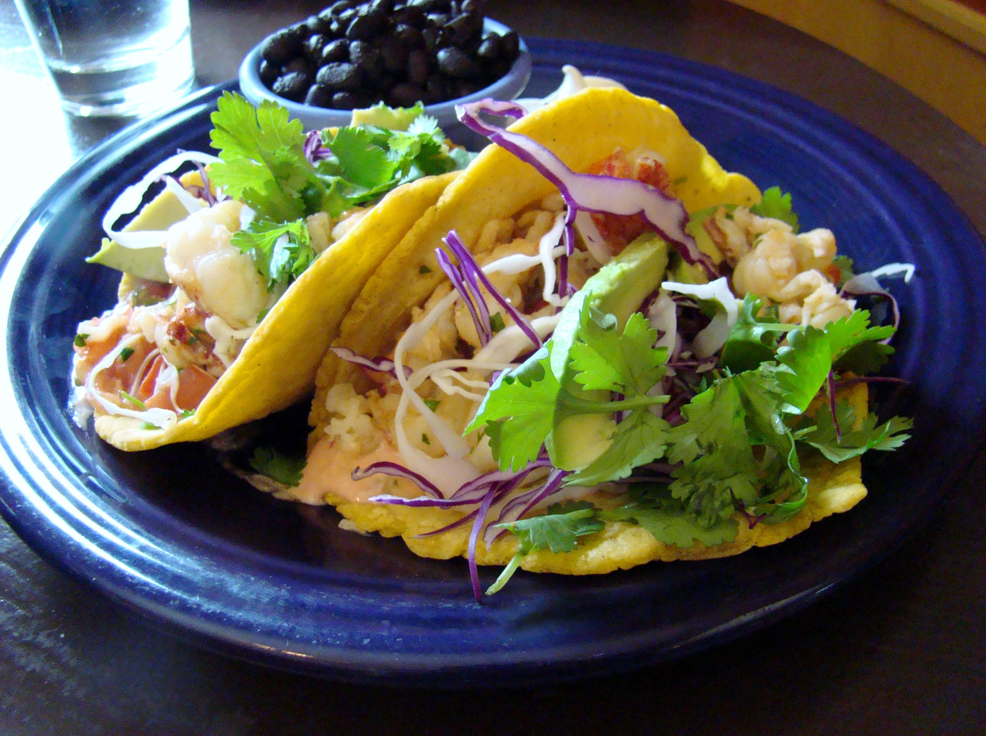 HOME KITCHEN CAFE - Lobster tacos come with black beans, avocado, red cabbage slaw, and cilantro.