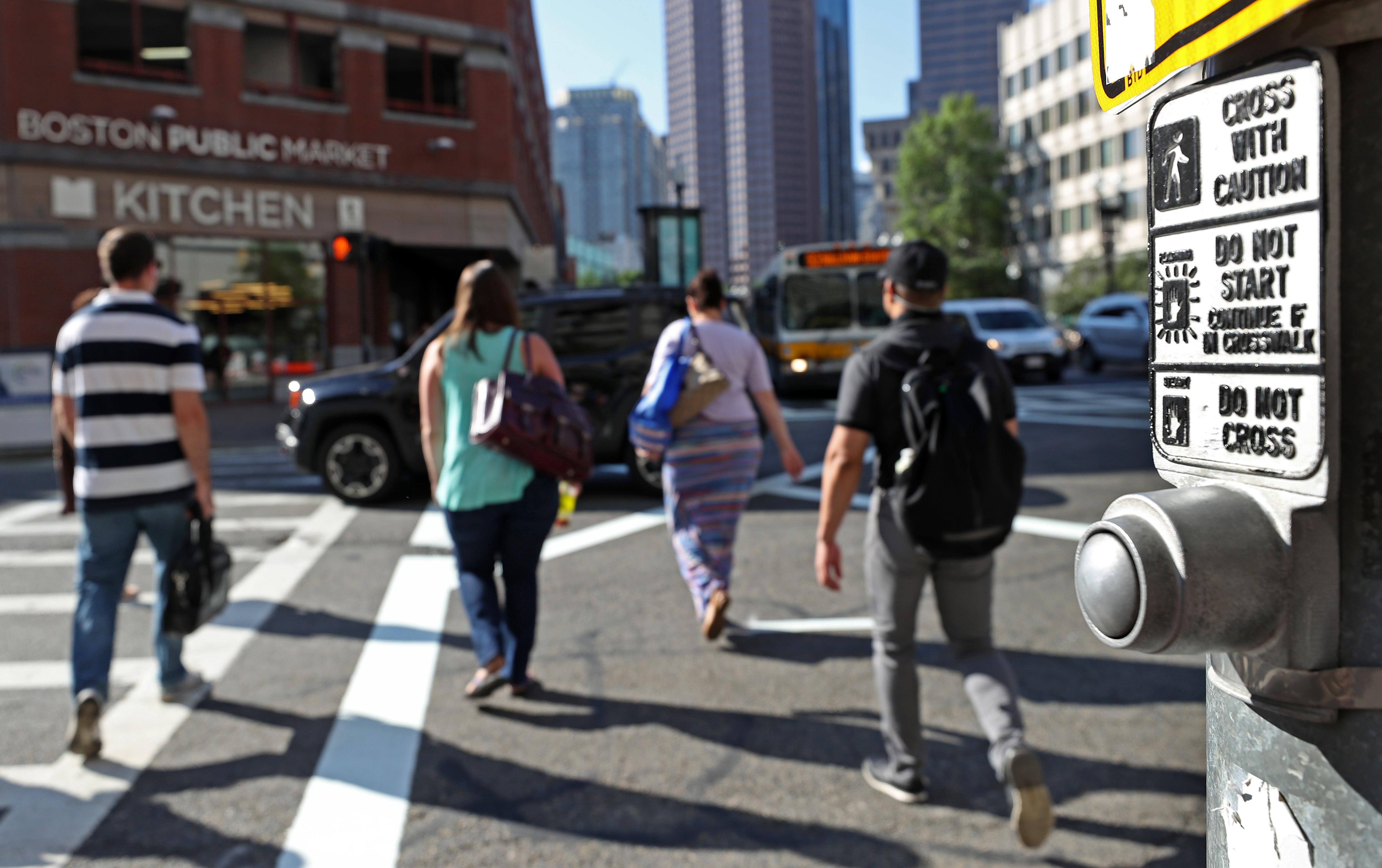 Some pedestrian mechanisms simply give an audible signal when it’s safe to cross. Above: Pedestrians cross at Congress and Sudbury streets during morning rush hour.