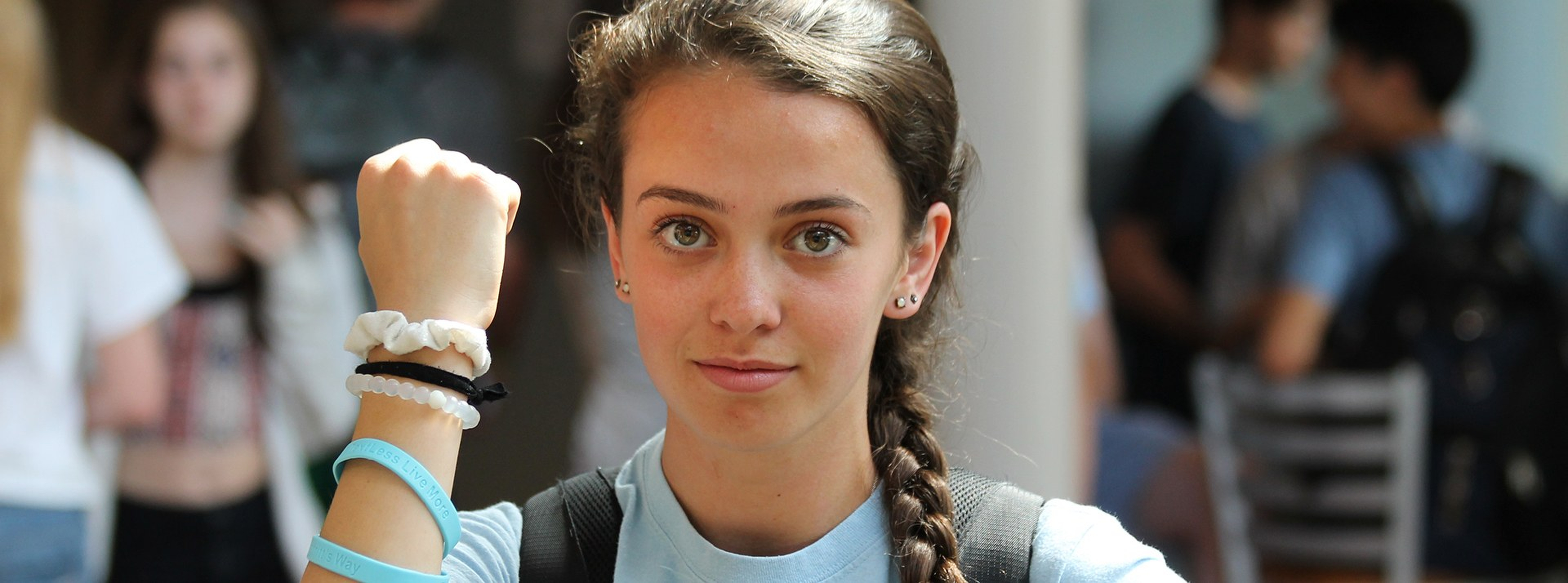 Milton Academy student Emily Bell wears a TextLess Live More bracelet . . .