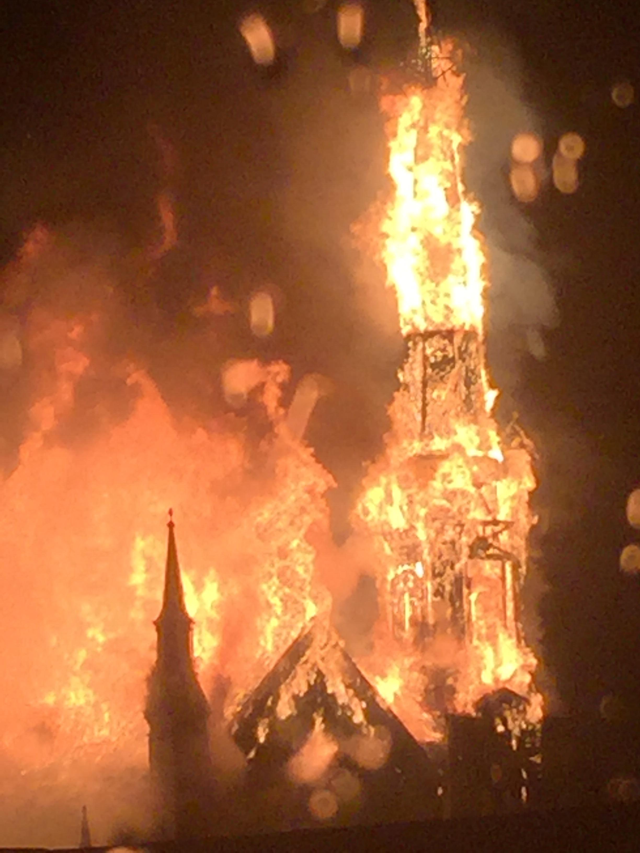 A witness took this photo when the spire was fully involved.