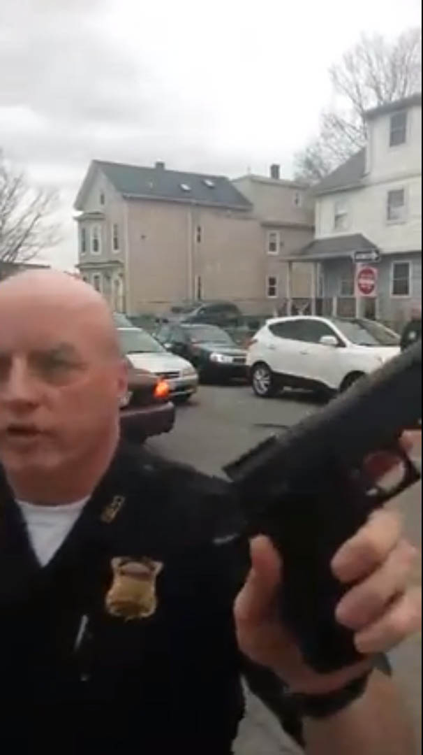 A Boston police officer held what appeared to be a gun to a civilian filming police activity in Roxbury last week.
