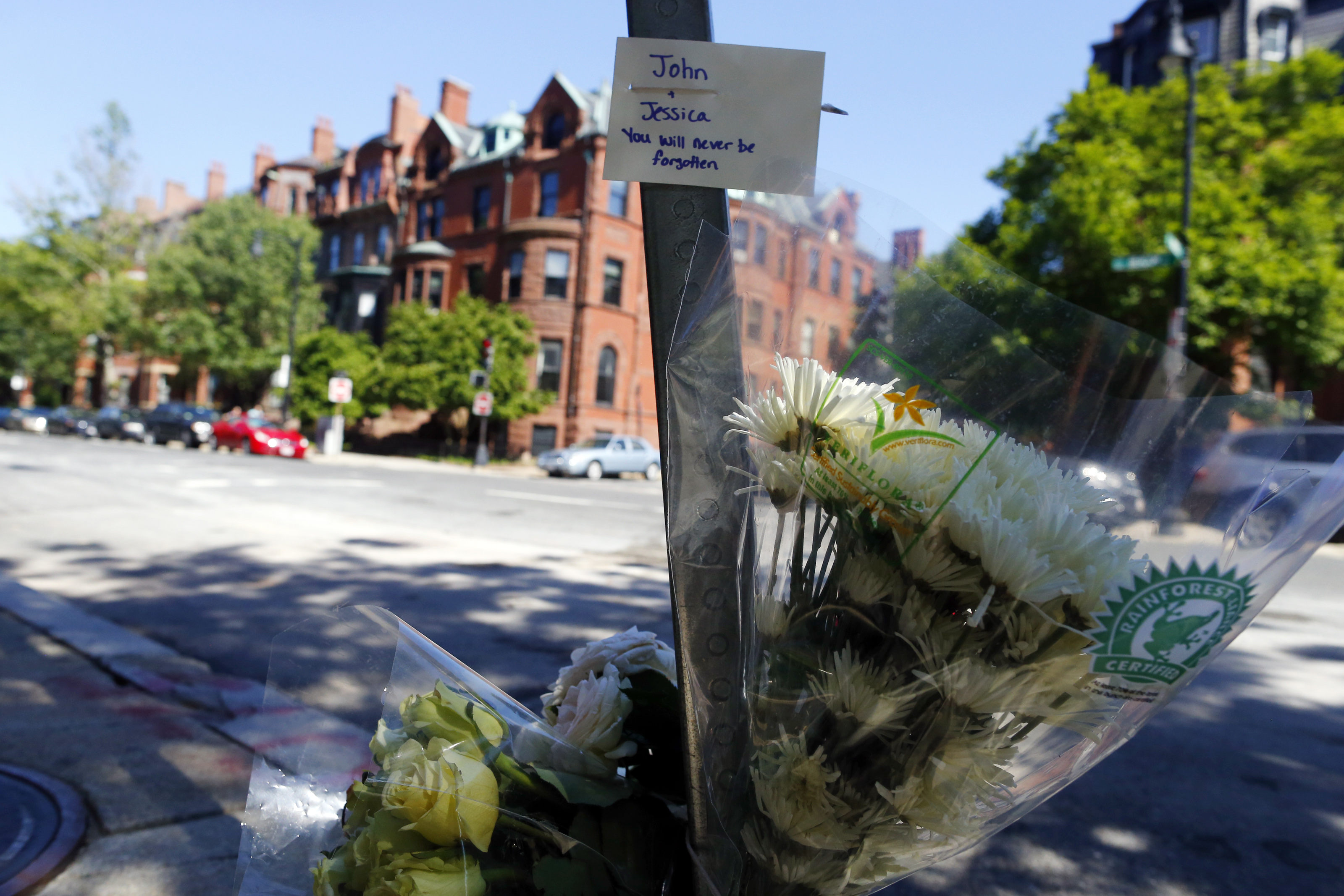 Mourners on Sunday left flowers and a note to the couple near the site on Beacon Street.