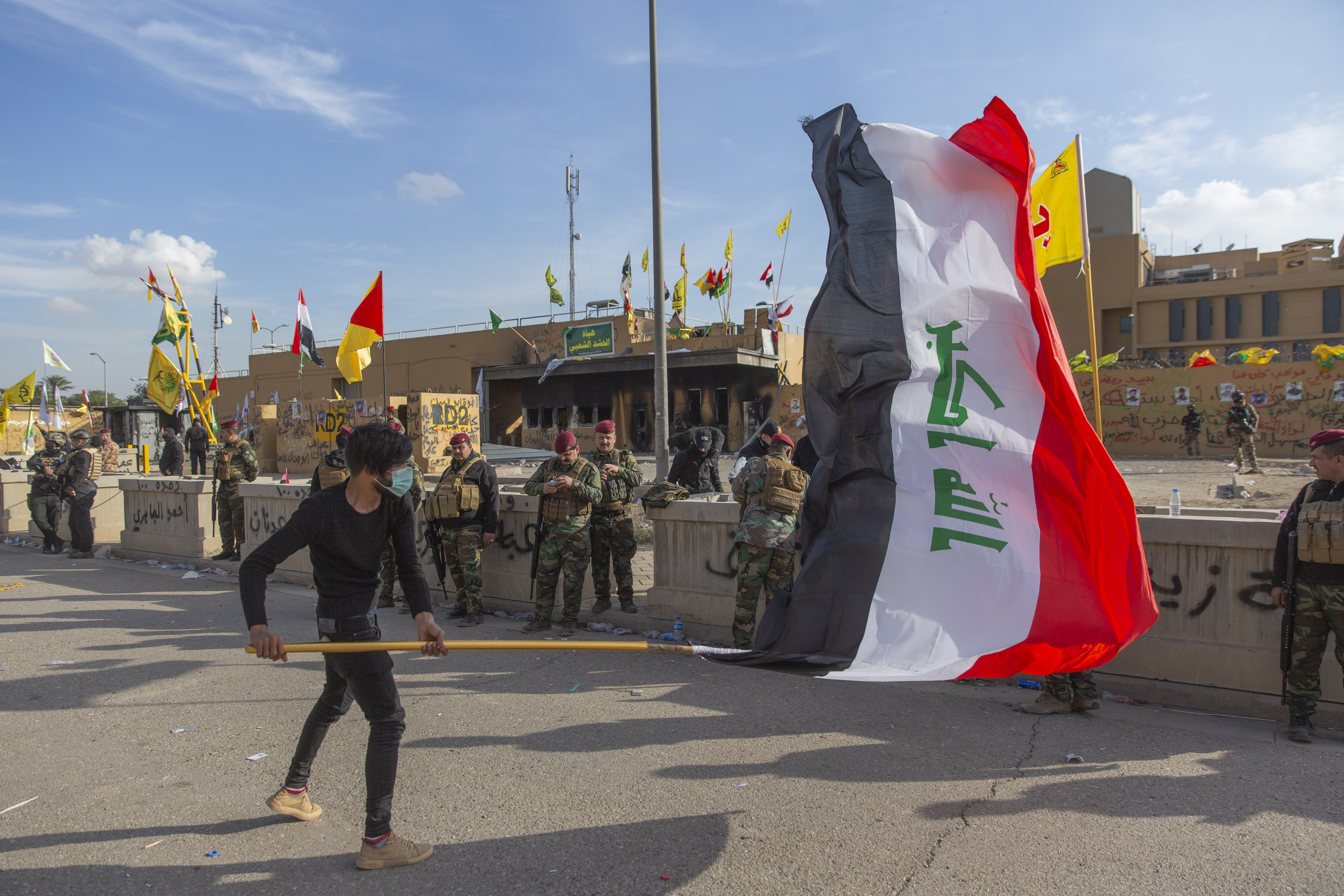 A man waved the Iraqi flag outside the American Embassy in Baghdad on New Year's Day.