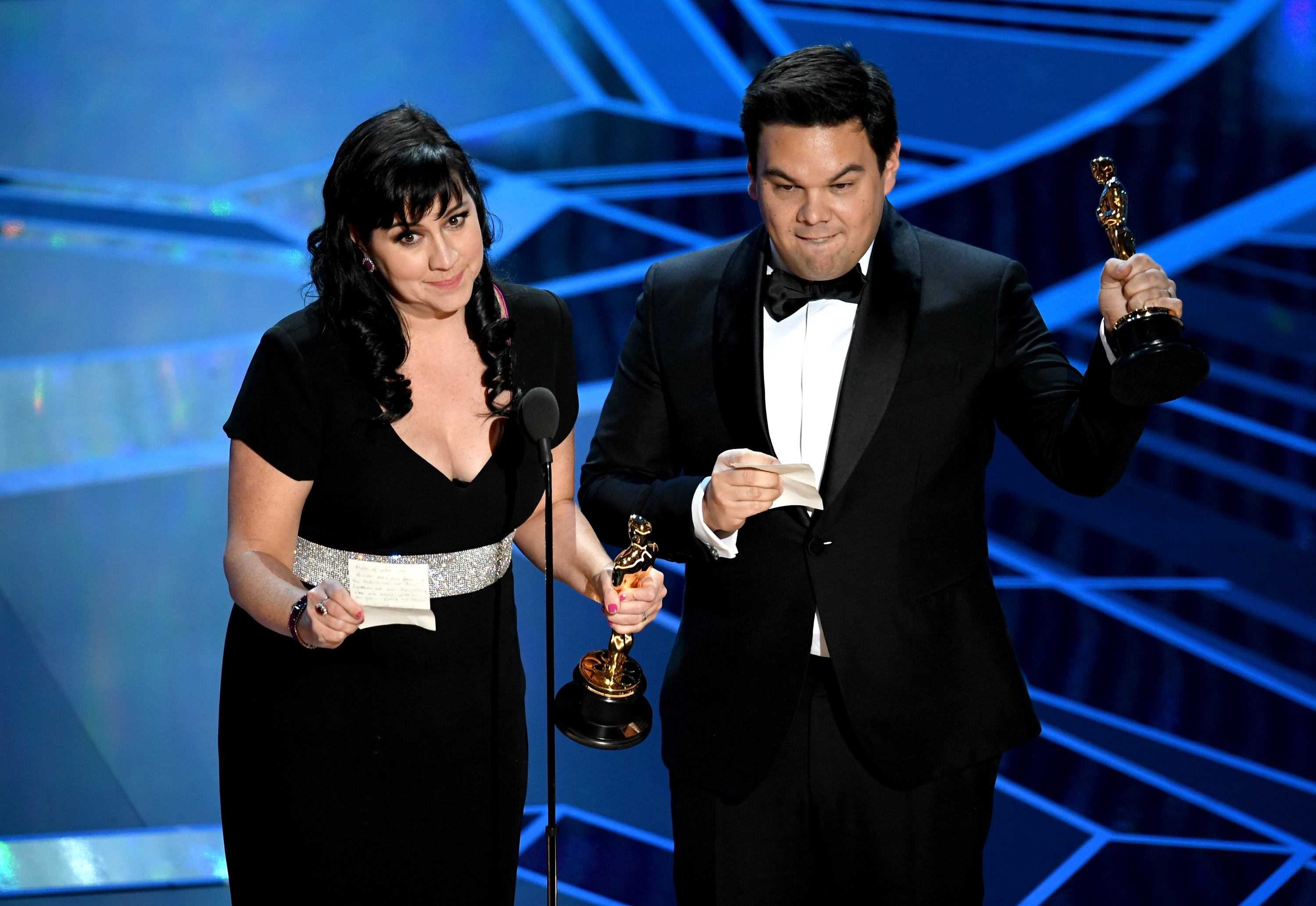 Songwriters Kristen Anderson-Lopez (left) and Robert Lopez accept Best Original Song for 'Remember Me' from 'Coco' onstage.