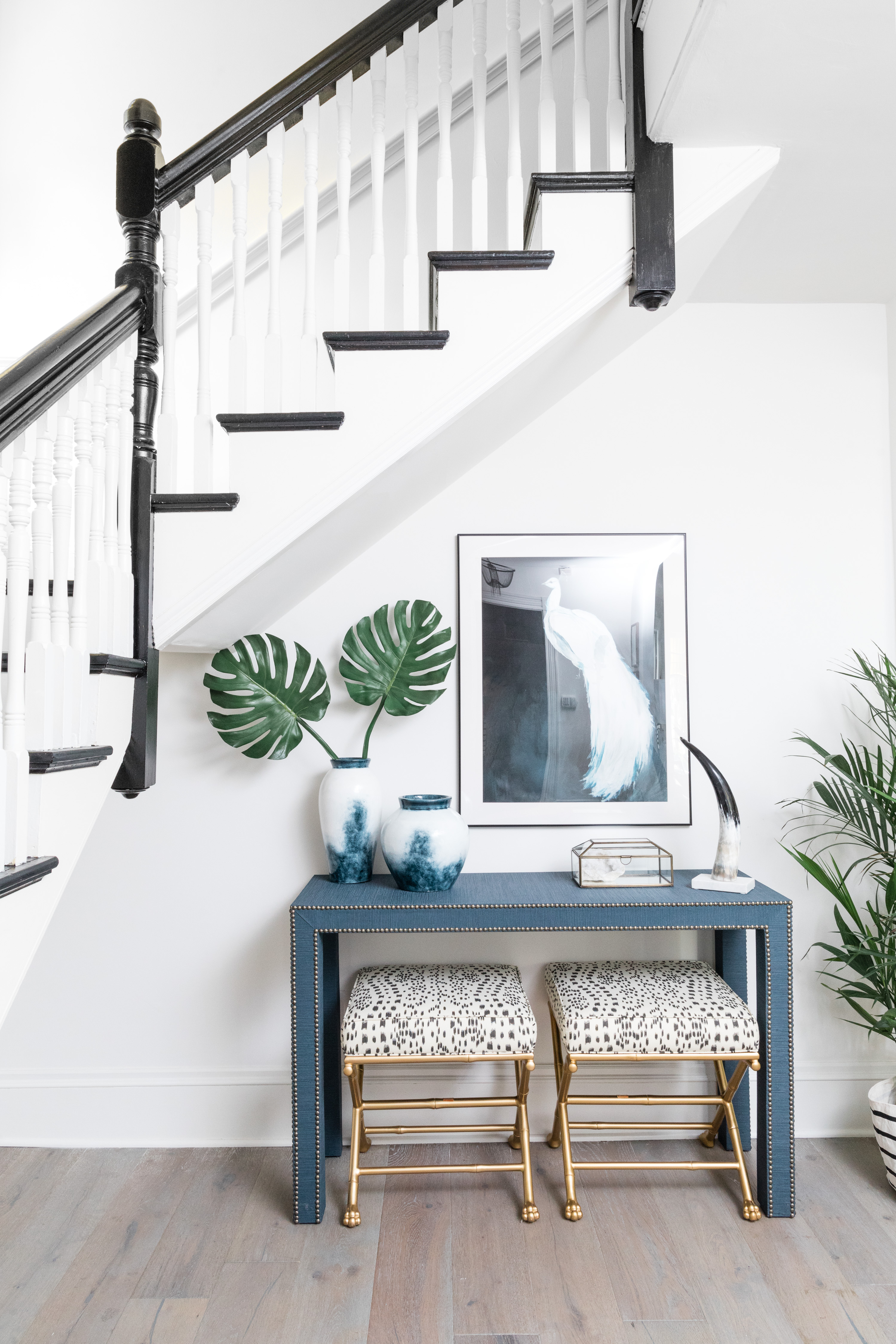 In the entry, faux-bamboo stools with hand-carved feet from Society Social tuck neatly away under the console when not in use. The framed peacock print by Christine Lindstrom is from Artfully Walls.