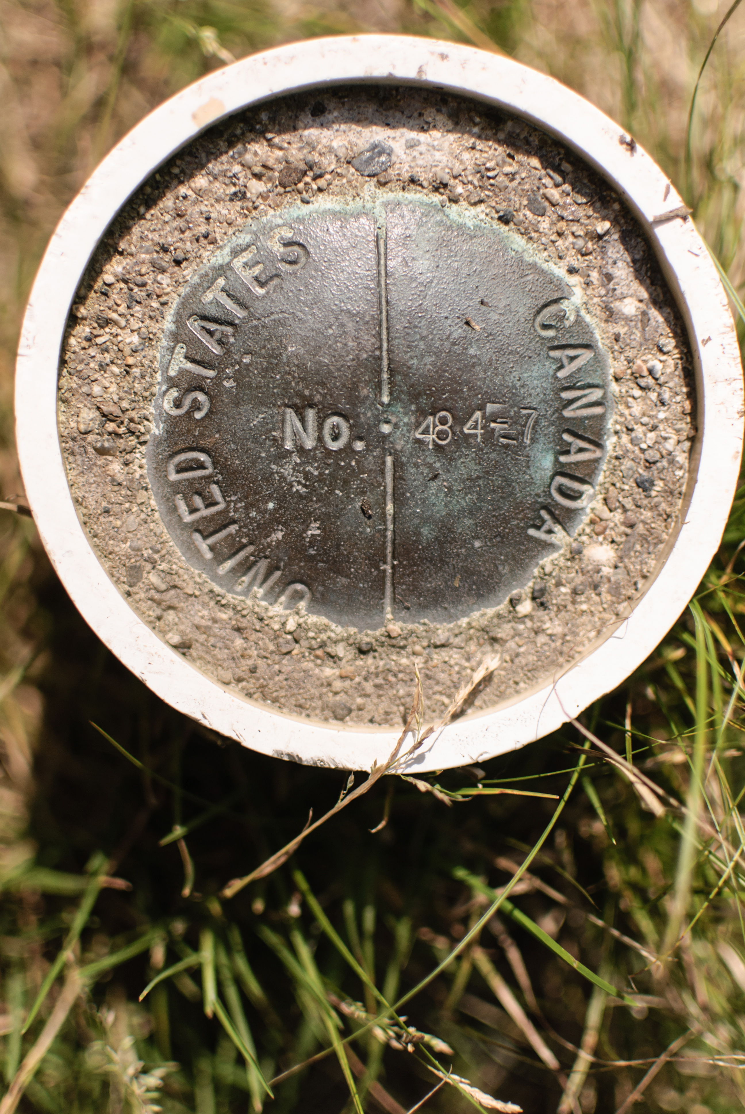 A marker on the international border along the trail leading to Fourth Connecticut Lake at the northern end of the Cohos Trail in New Hampshire.